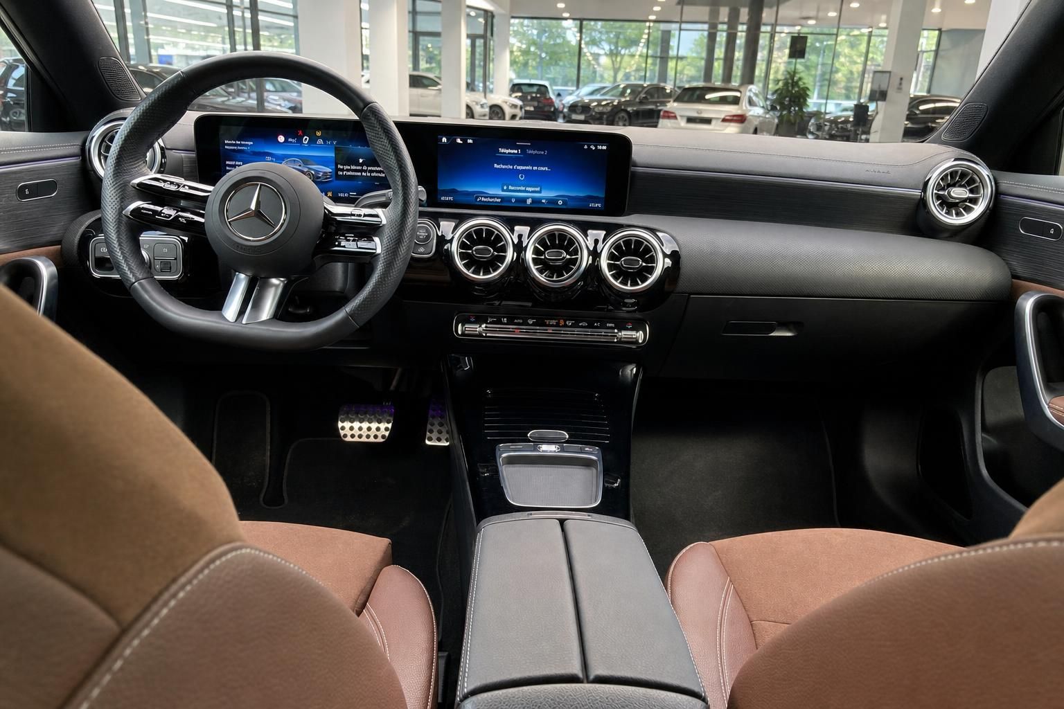 Innenraum eines Mercedes-Benz mit Lenkrad, Displays und brauner Mittelkonsole