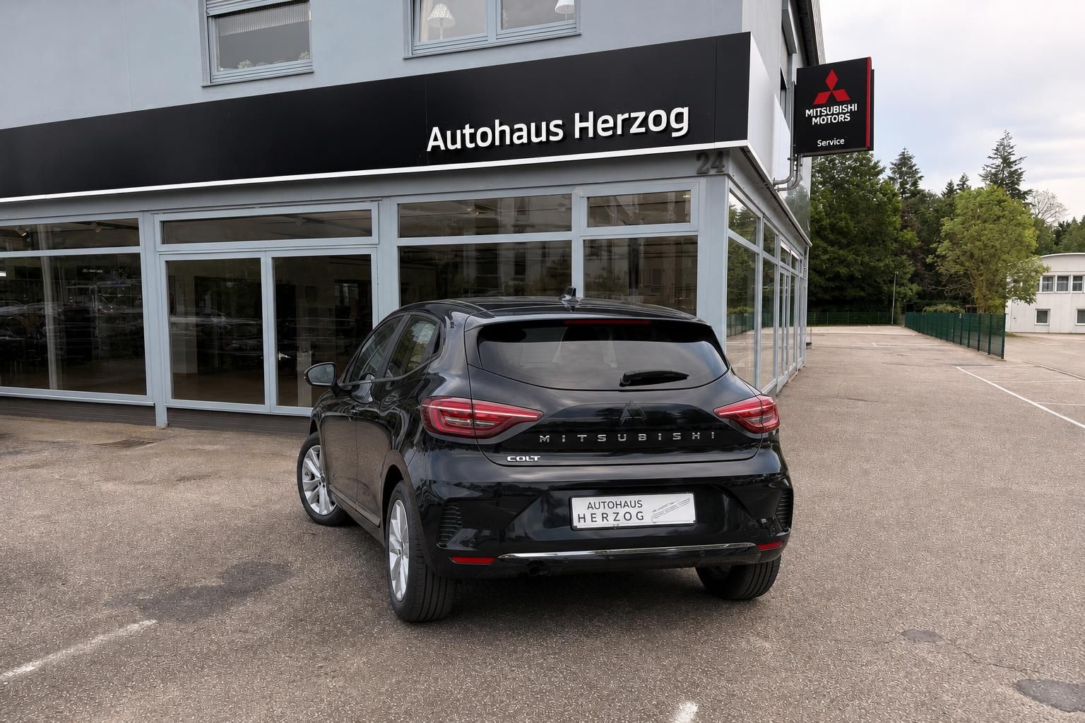 Schwarzer Mitsubishi Colt Heckansicht vor Autohaus Herzog - Rückseite mit LED-Rückleuchten und Kennzeichen
