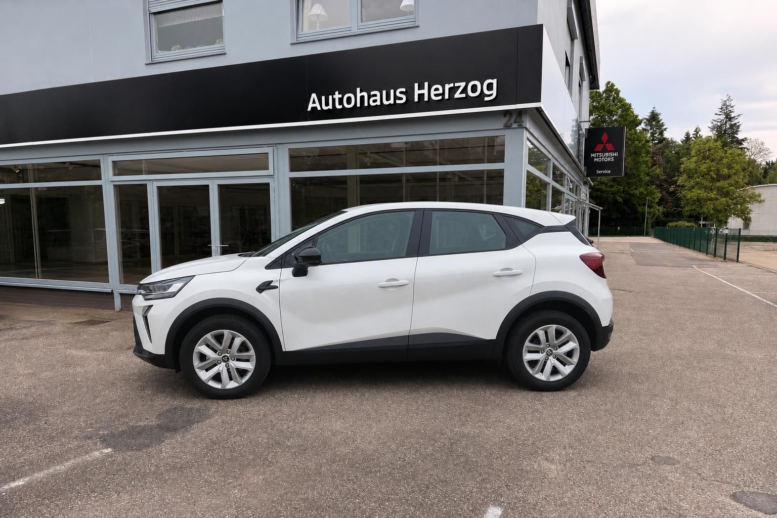 Weißer Mitsubishi SUV Seitenansicht - kompakter Crossover vor Autohaus Herzog