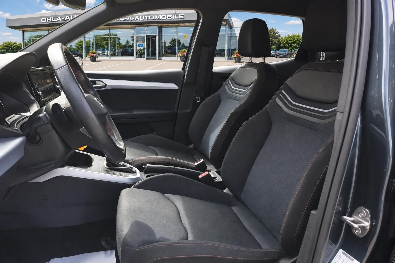 Innenraum Seat Arona mit Sportsitzen und Blick auf Autohaus