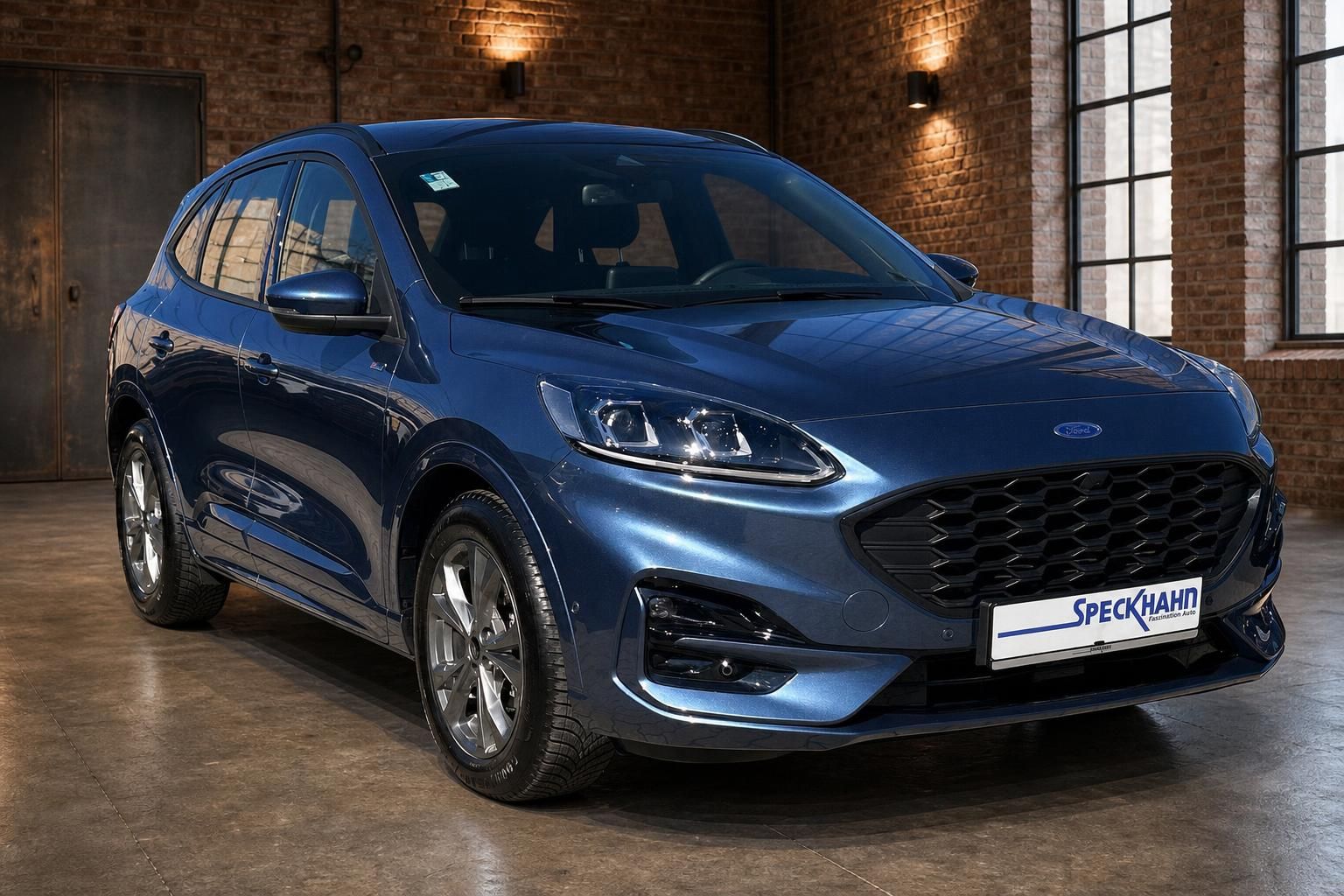 Ford Kuga blau Frontansicht schraeg in Industriehalle mit Backstein