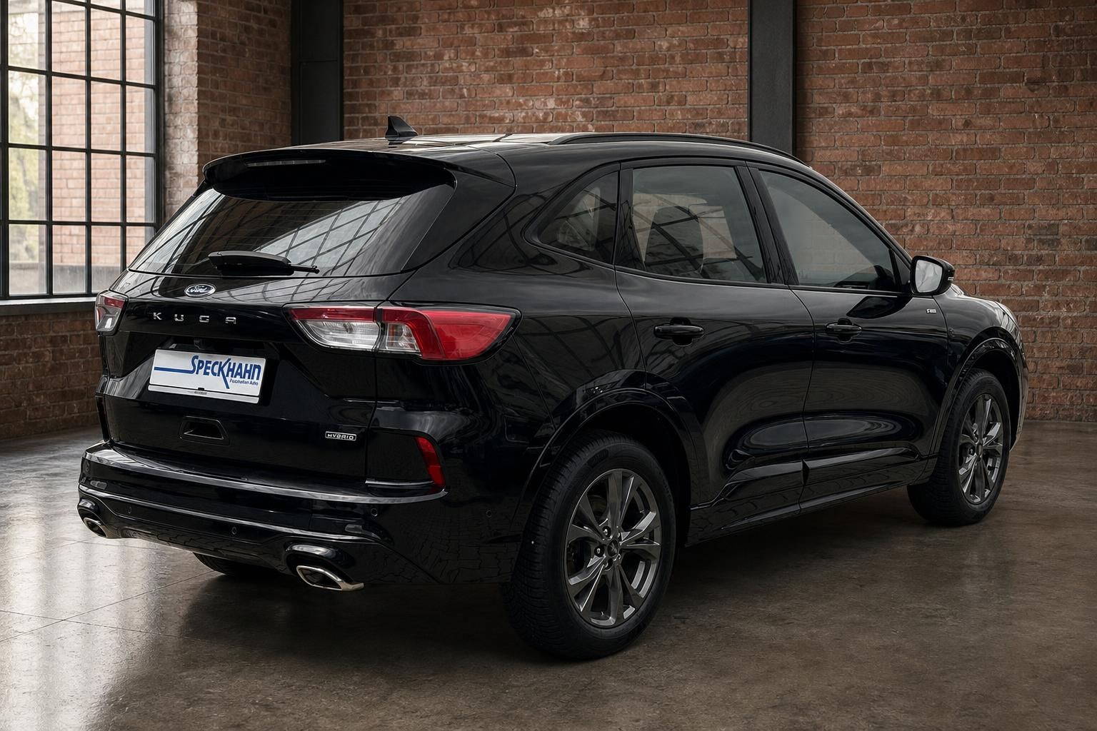 Ford Kuga Hybrid schwarz Heck seitlich vor Backsteinwand