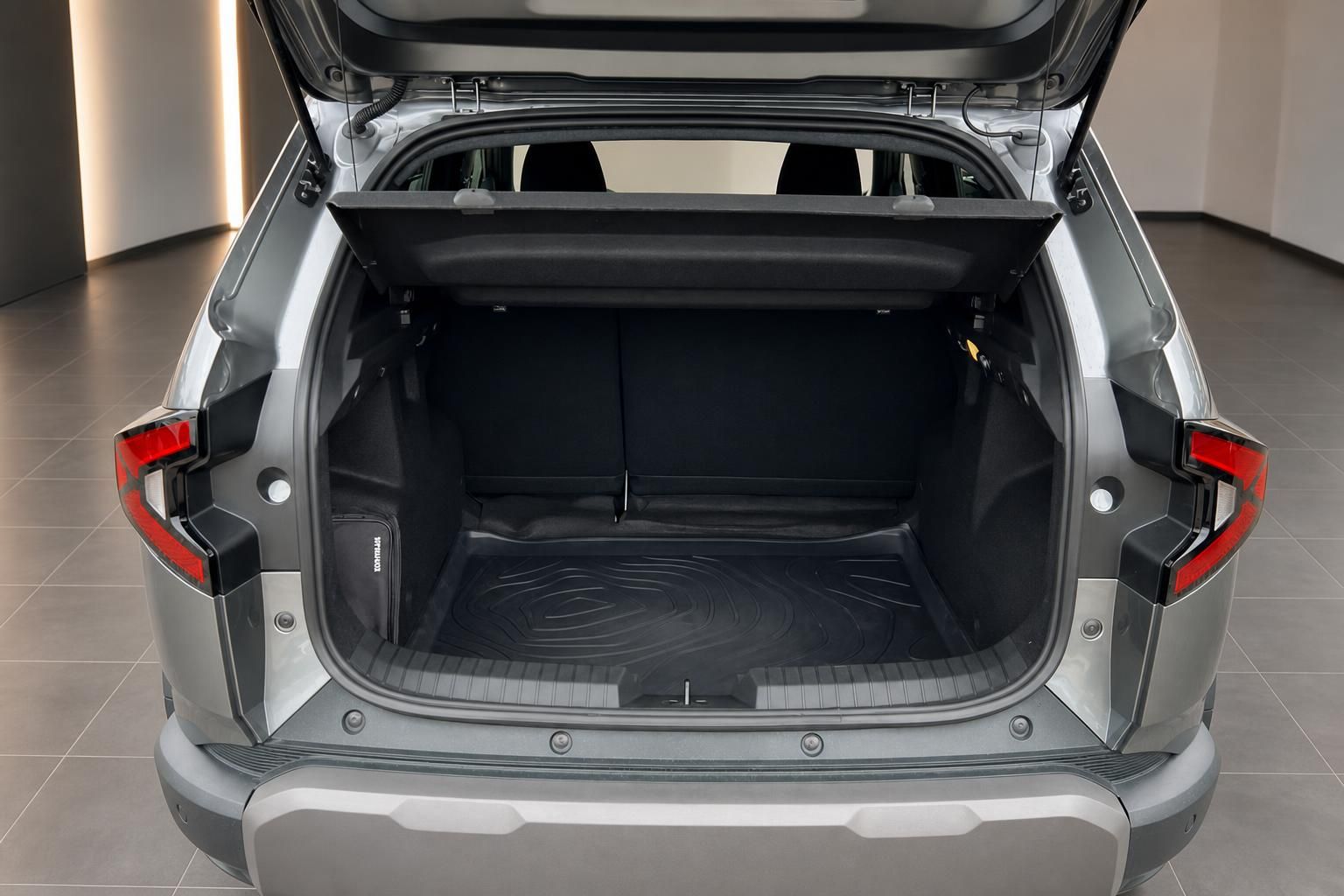 Geöffneter Kofferraum eines silbernen SUV mit Gummimatte und klappbaren Rücksitzen
