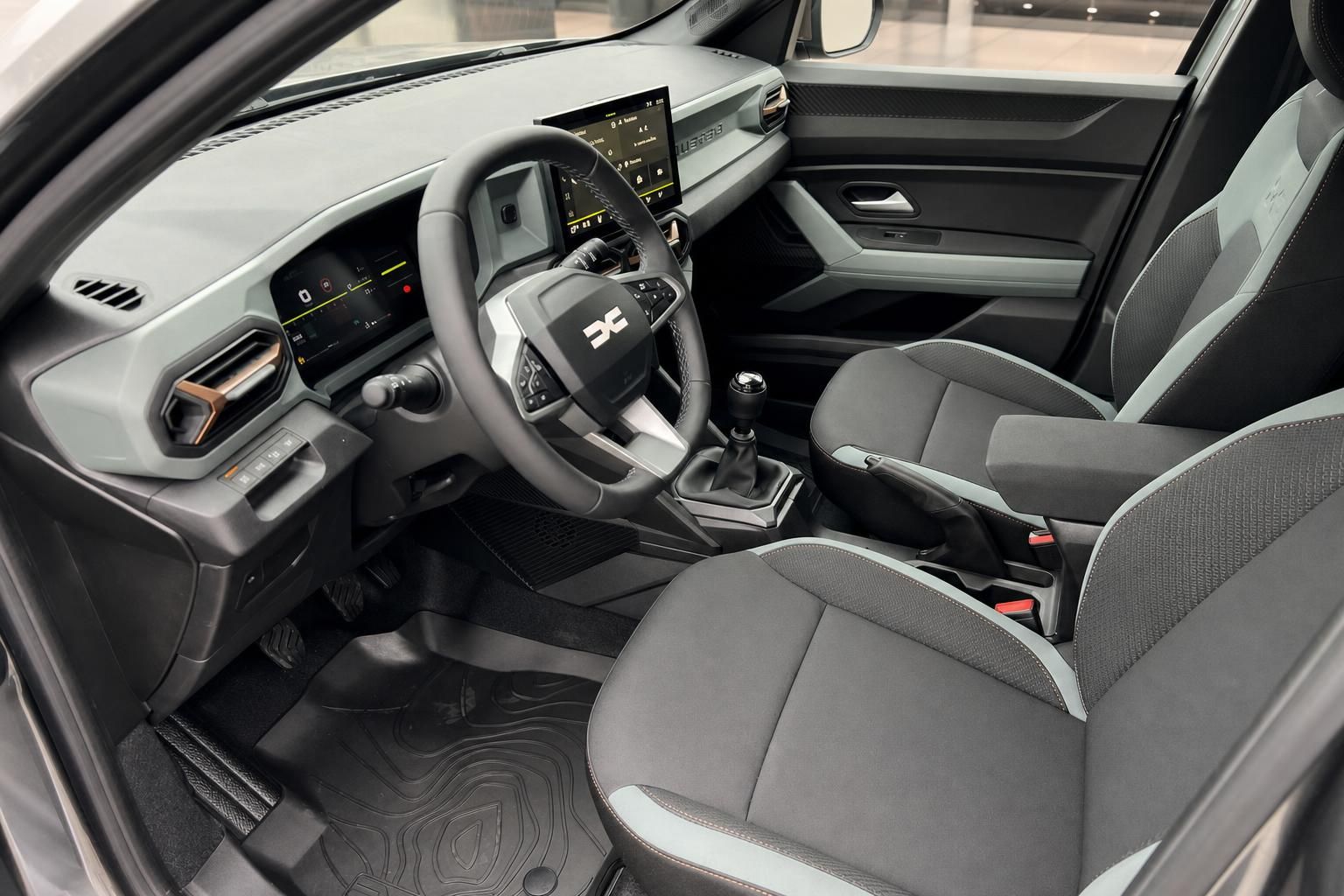 Fahrzeuginnenraum mit Lenkrad, Touchscreen-Display und grauer Polsterung - Cockpit-Detailansicht
