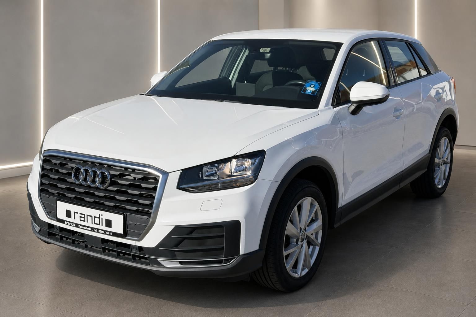 Audi Q2 weiss Dreiviertelperspektive vorne links im Autohaus Showroom