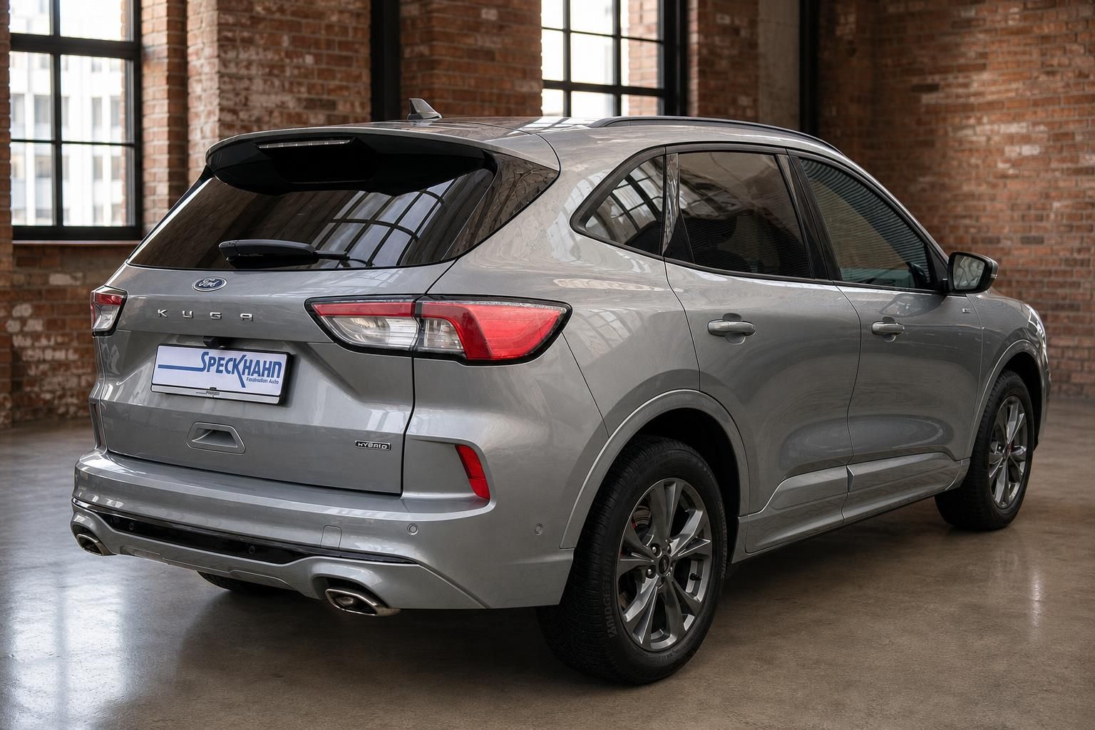 Ford Kuga Hybrid Silber, Heck-Seitenansicht im Loft-Showroom