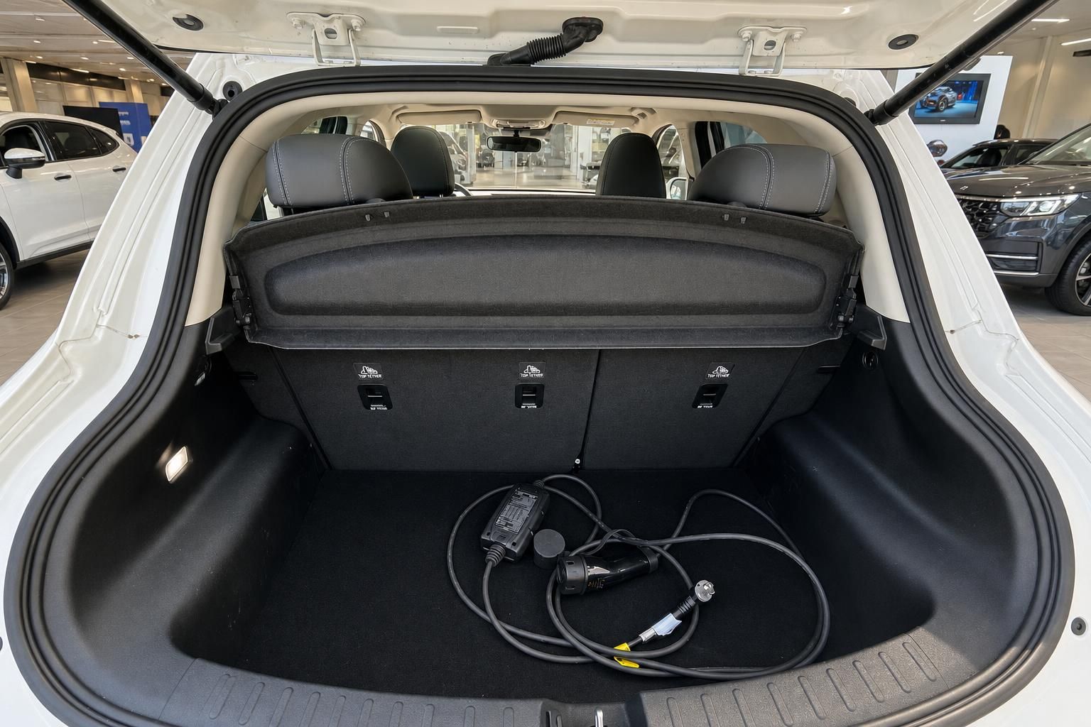 Kofferraum mit schwarzer Auskleidung und Ladekabel für Elektrofahrzeug