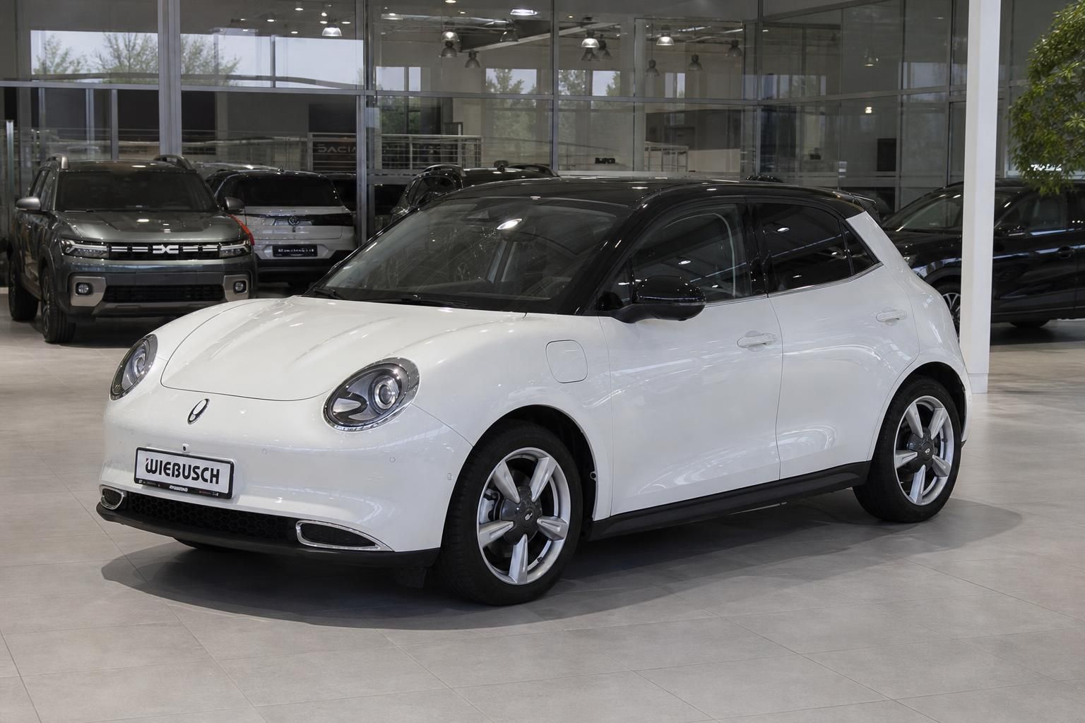 Weißer Elektro-Kleinwagen ORA Funky Cat im Autohaus-Showroom, Frontansicht mit schwarzem Dach