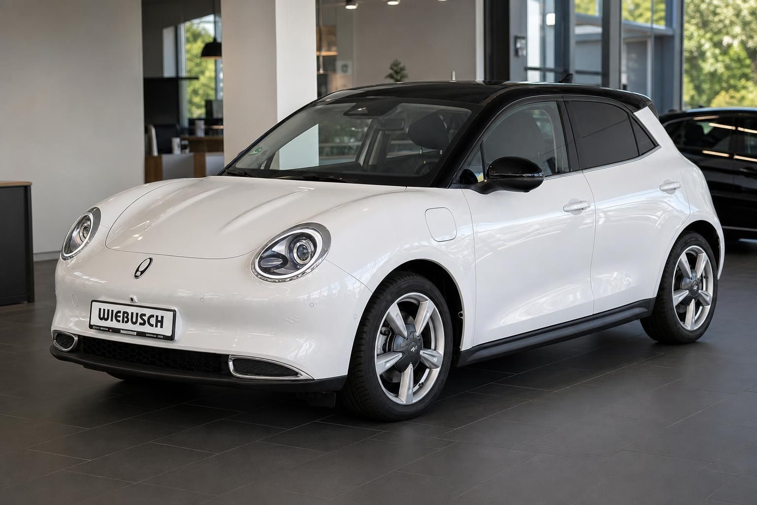 Weißer Elektro-Kleinwagen im Autohaus-Showroom mit schwarzem Dach und modernem Design