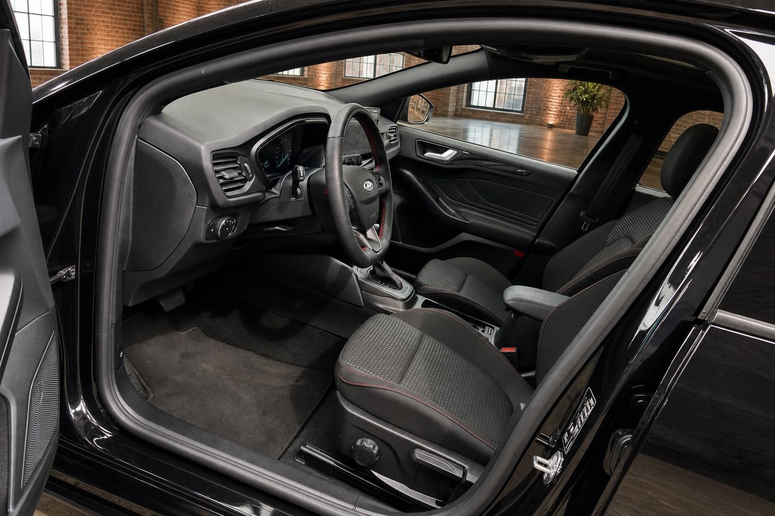 Ford Focus Innenraum – Cockpit und Vordersitze mit roter Ziernaht