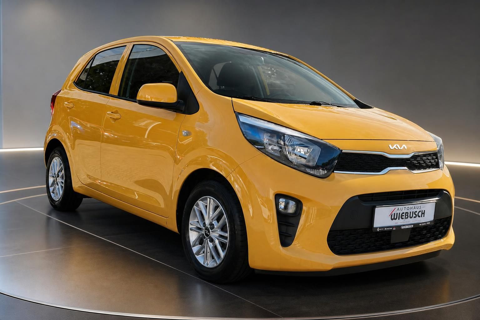 Kia Picanto gelb Frontansicht schräg rechts auf Drehteller – Kleinwagen Autohaus Wiebusch