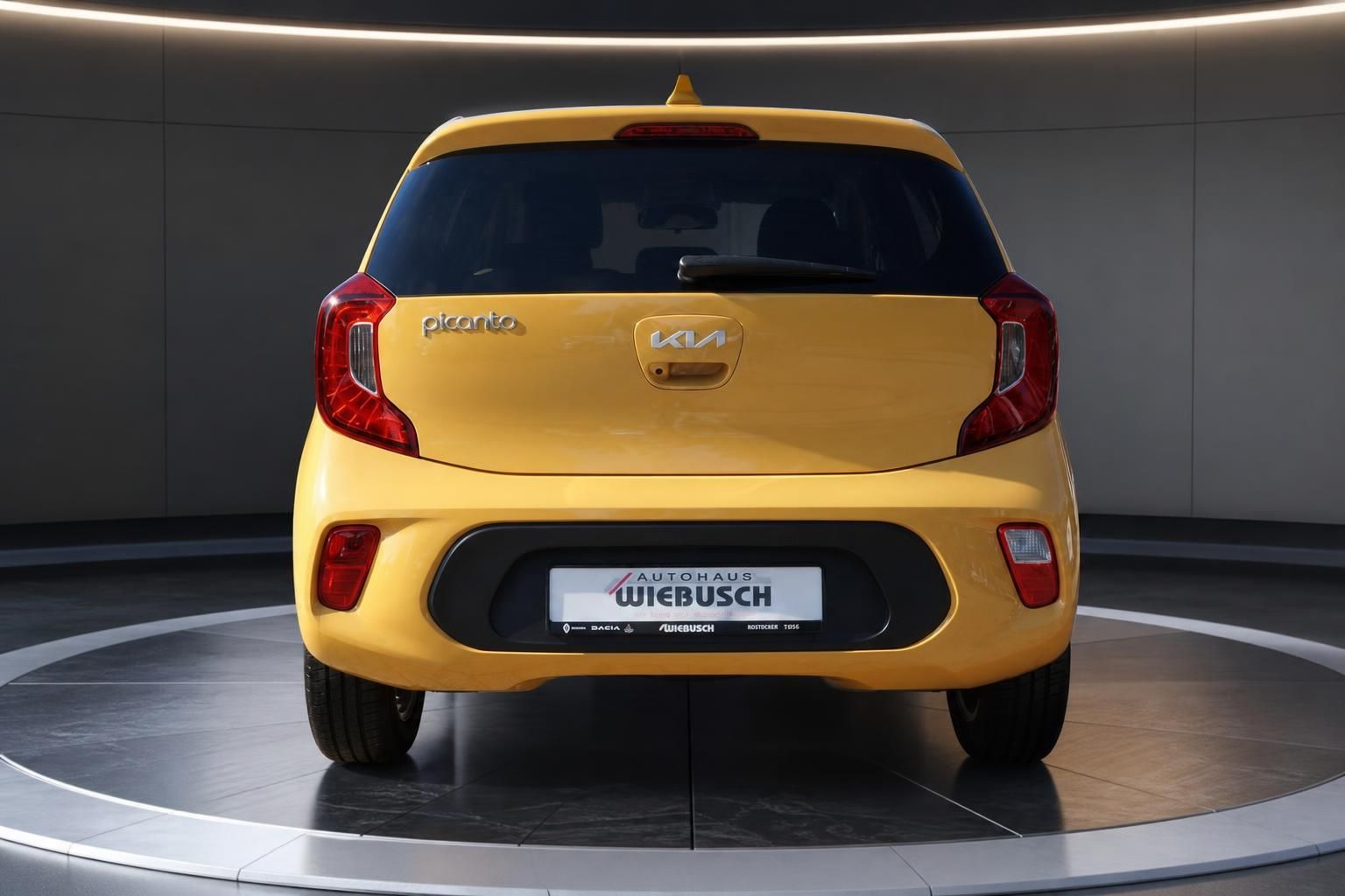 Kia Picanto gelb Heckansicht auf Drehteller – kompakter Kleinwagen bei Autohaus Wiebusch