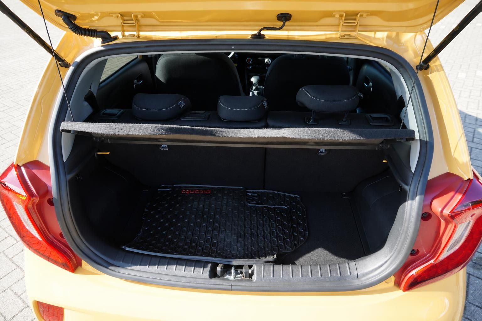 Kia Picanto Kofferraum geöffnet mit Laderaumabdeckung und Gummimatte in Gelb