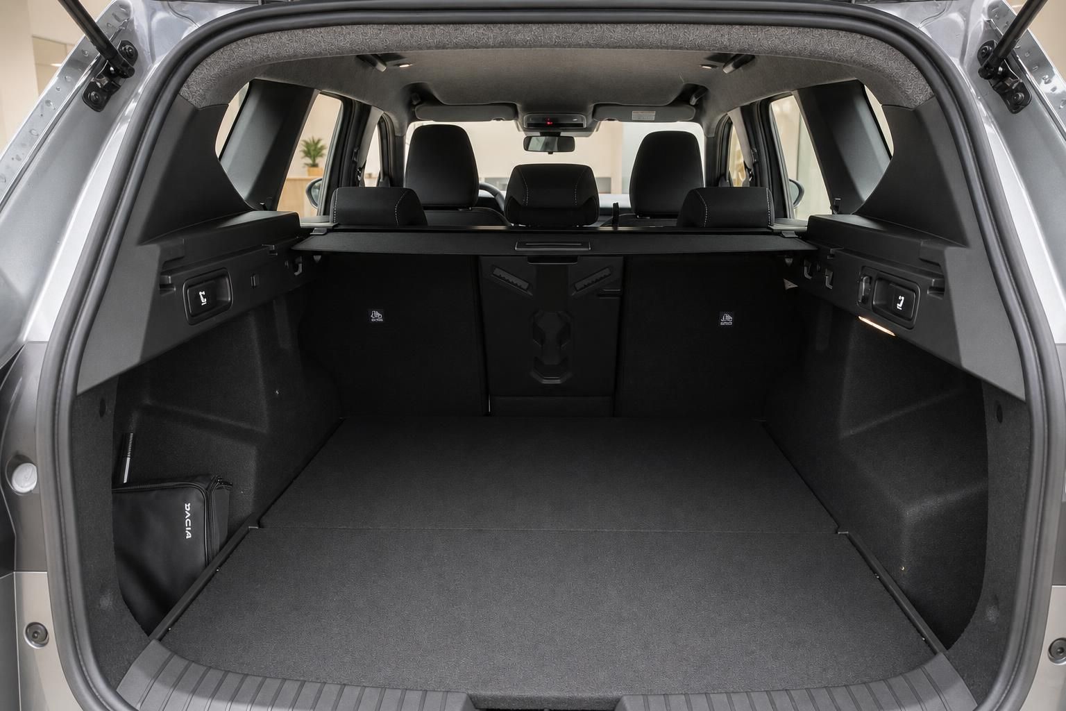 Dacia Kofferraum geöffnet mit großem Laderaum, umgeklappten Sitzen und Bordtasche