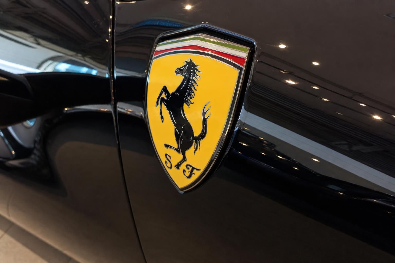 Ferrari Logo Wappen in gelb mit schwarzem Pferd auf schwarzer Karosserie
