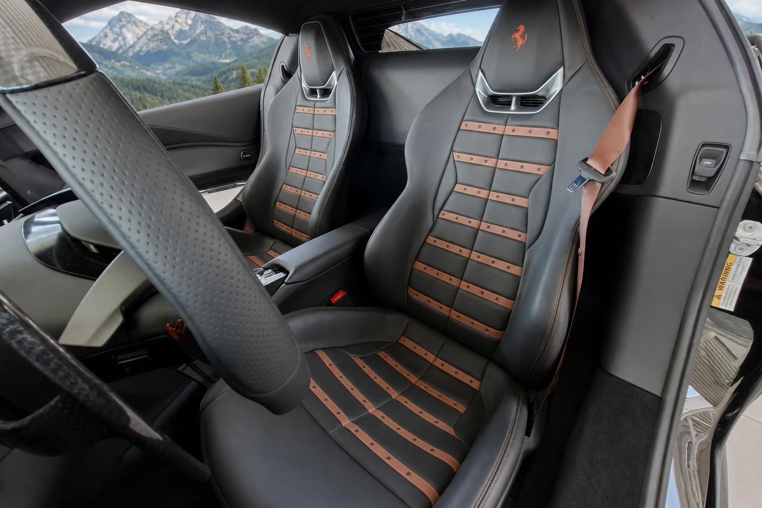 Ferrari Innenraum mit grau-orangen Ledersitzen und Ferrari-Logo