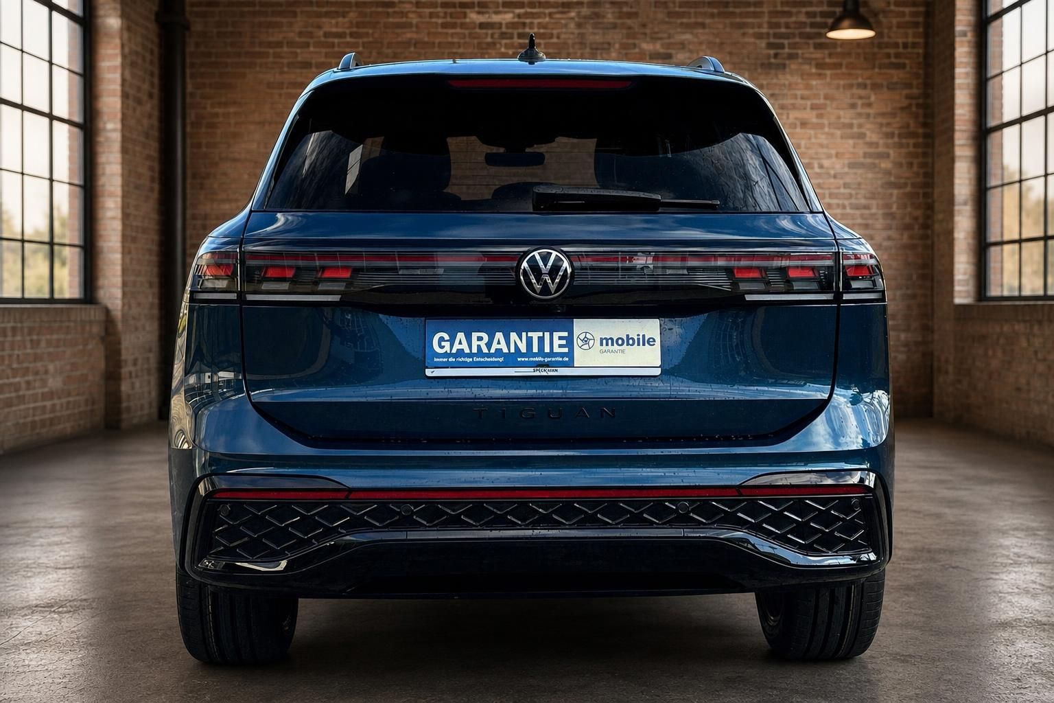 VW Tiguan dunkelblau Heckansicht frontal in Backsteinhalle