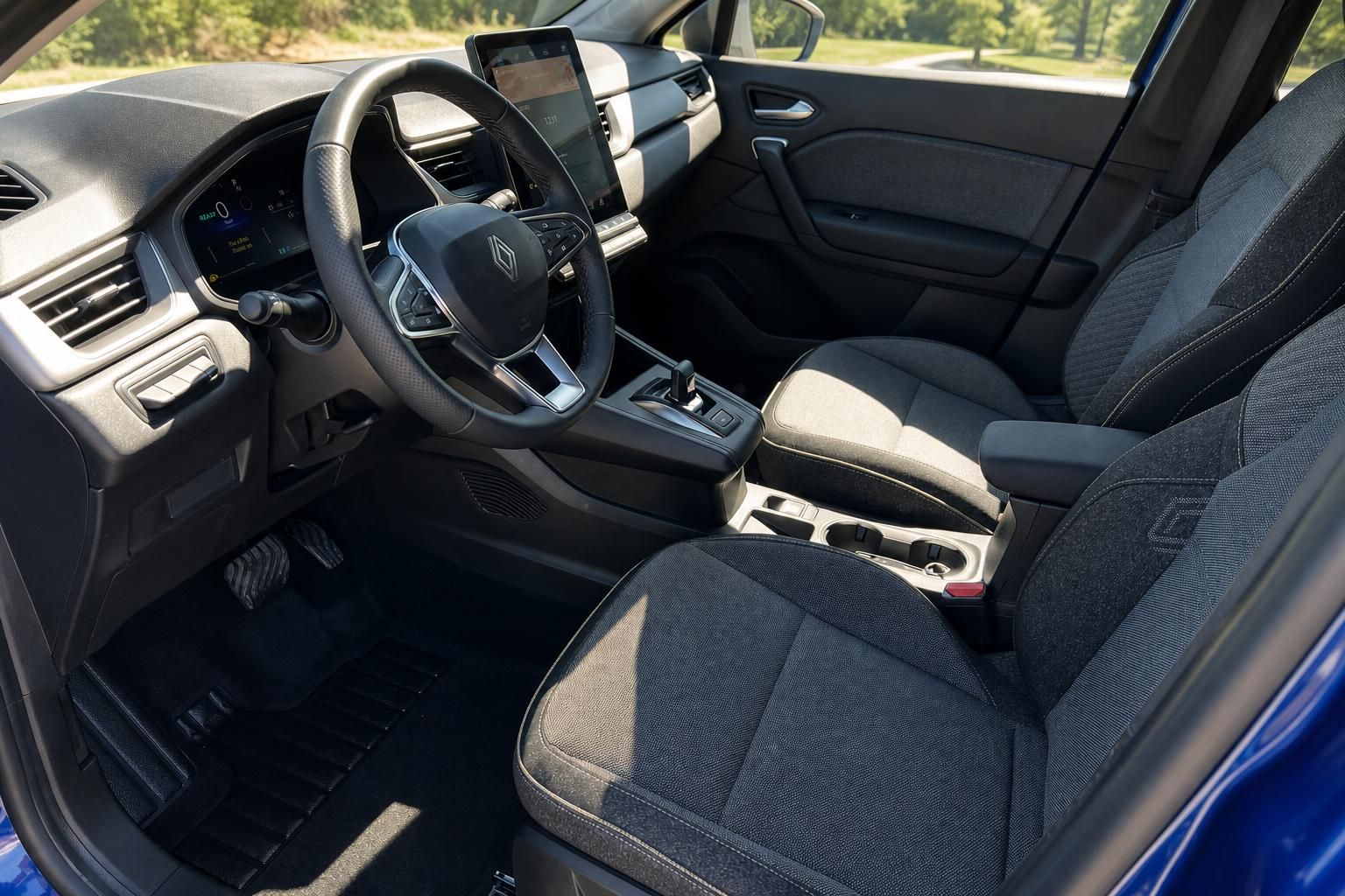 Renault Innenraum mit schwarzem Lenkrad, Touchscreen und Stoffsitzen in dunkler Ausstattung