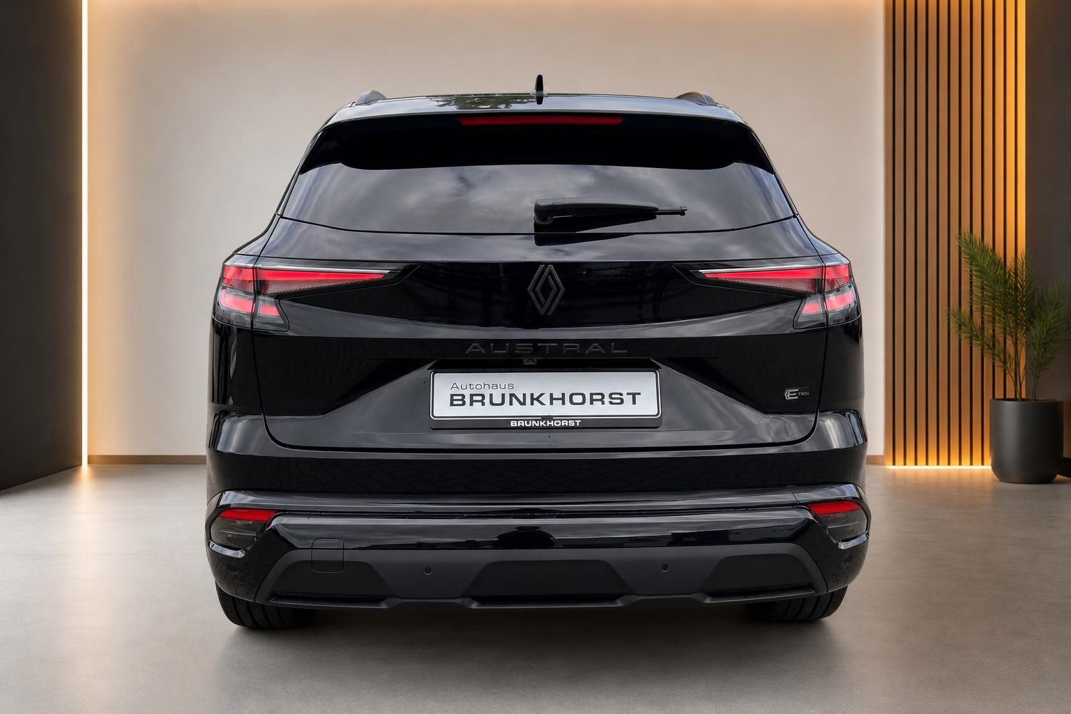 Renault Austral in Schwarz, Heckansicht in modernem Showroom