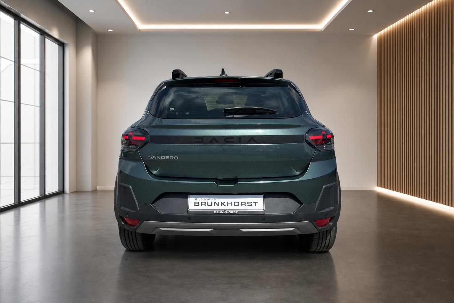 Dacia Sandero heckansicht grün metallic mit Rücklichtern im modernen Autohaus Showroom