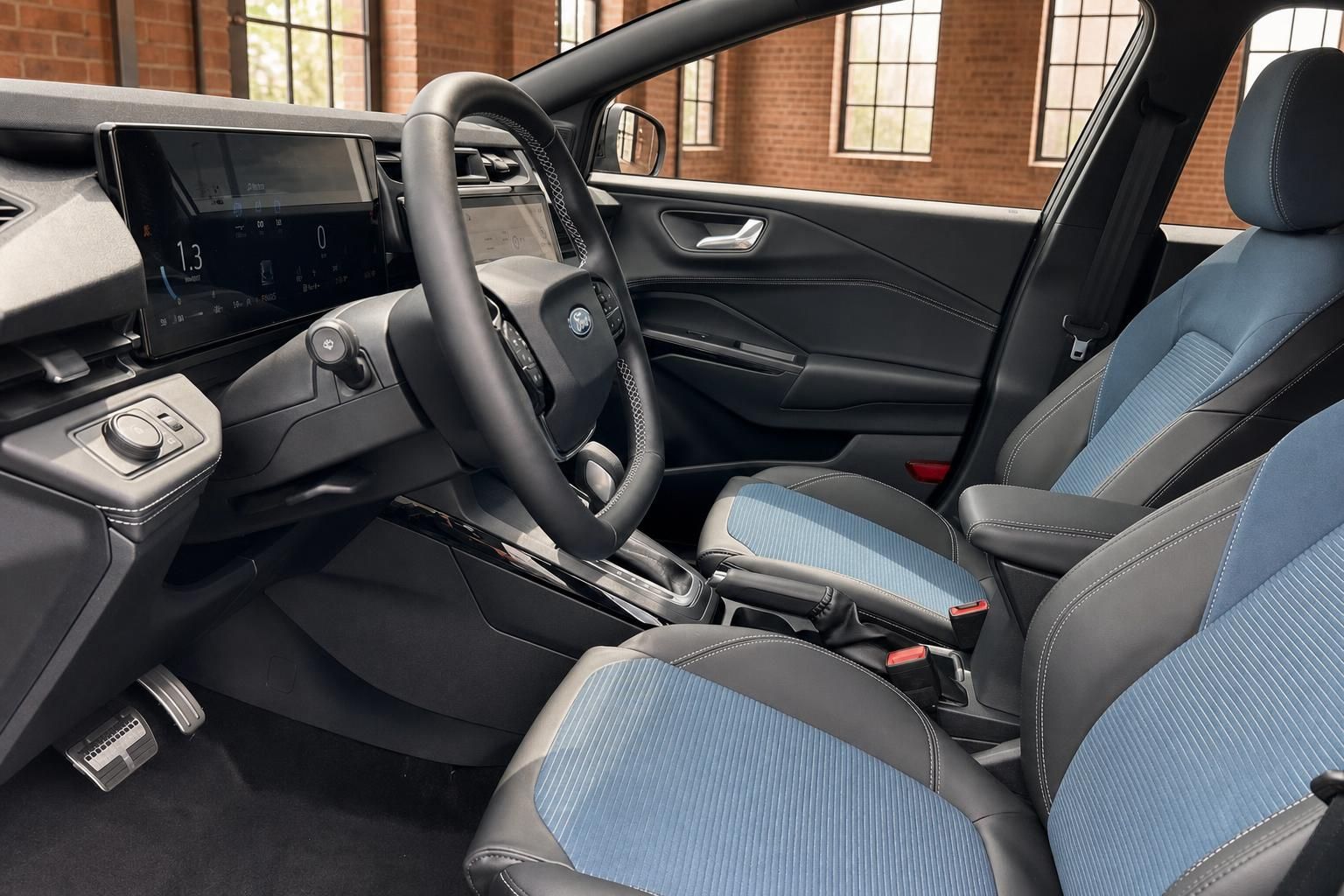 Ford Fahrzeuginnenraum Fahrerseite mit Lenkrad, Schalthebel und blauen Stoffsitzen