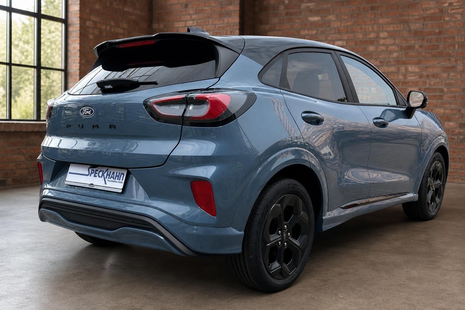 Ford Puma blau Heckansicht schräg rechts schwarze Felgen Spoiler Gebrauchtwagen