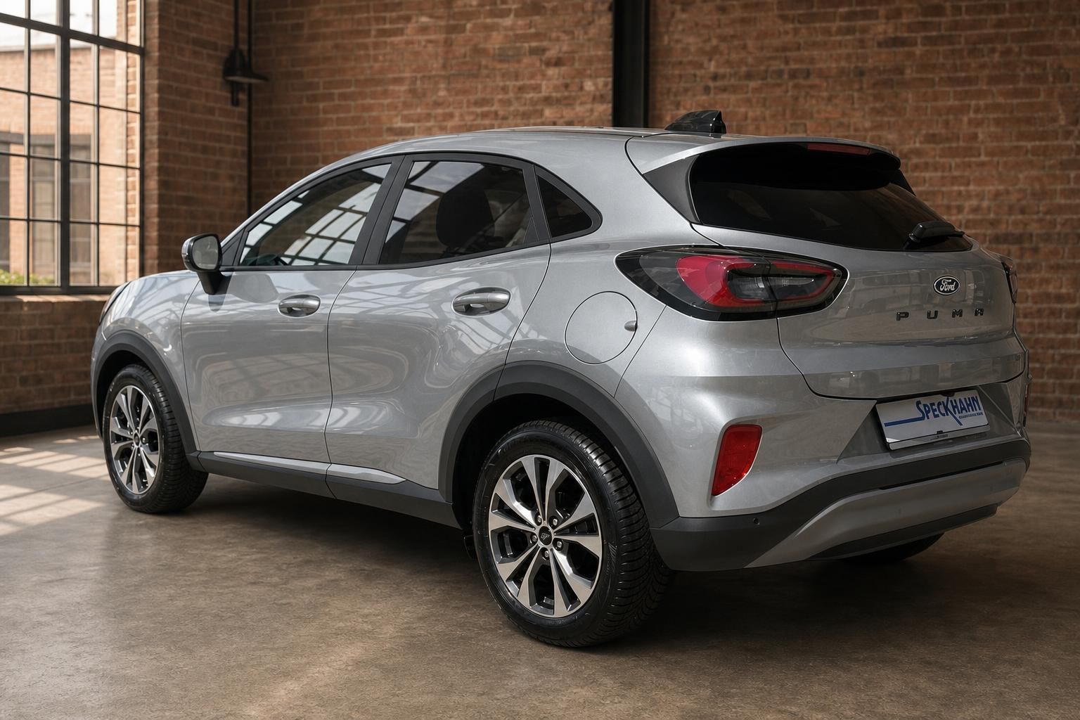 Ford Puma silber Heck seitlich vor rustikaler Backsteinwand