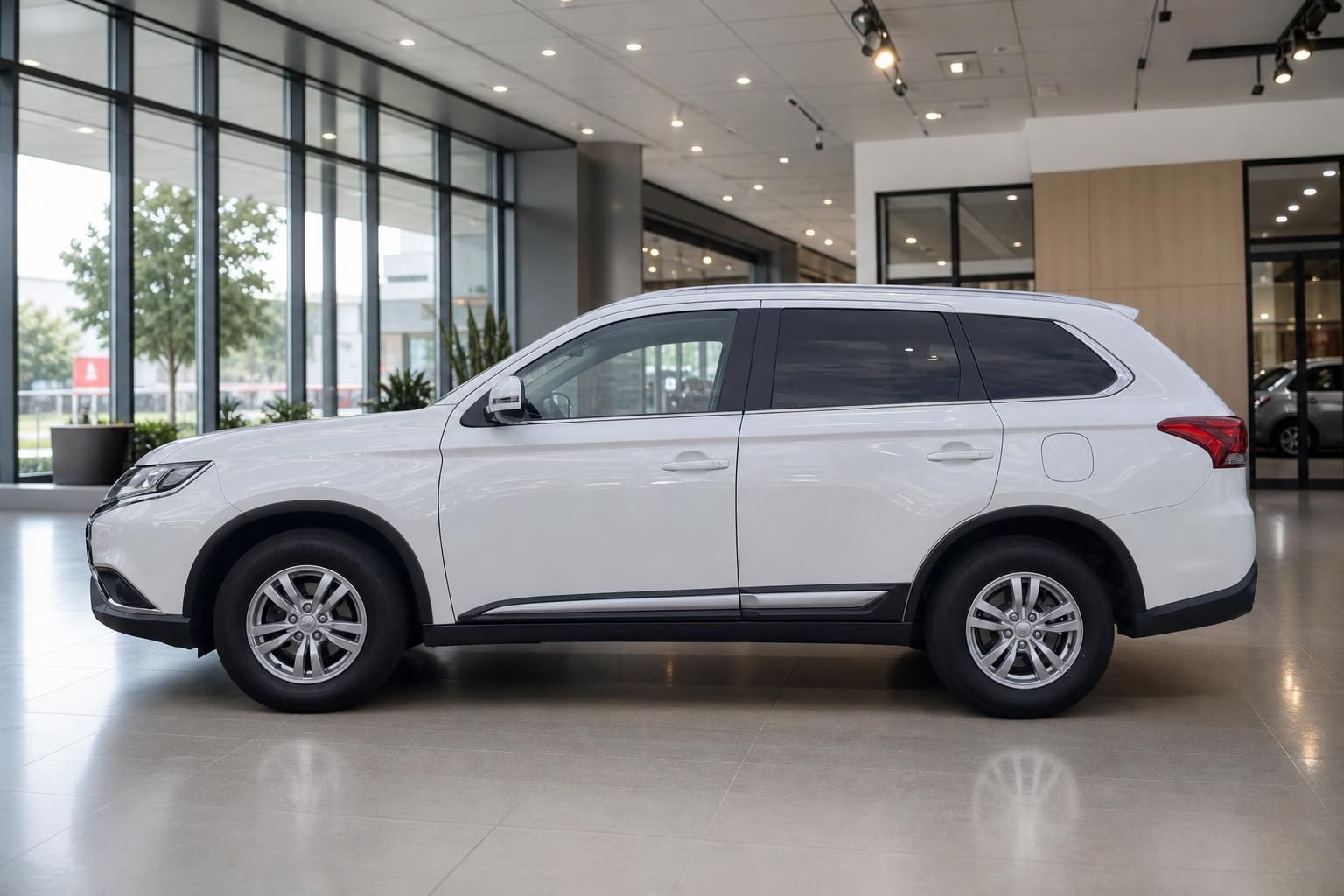 Mitsubishi Outlander weiß Seitenansicht im modernen Autohaus-Showroom
