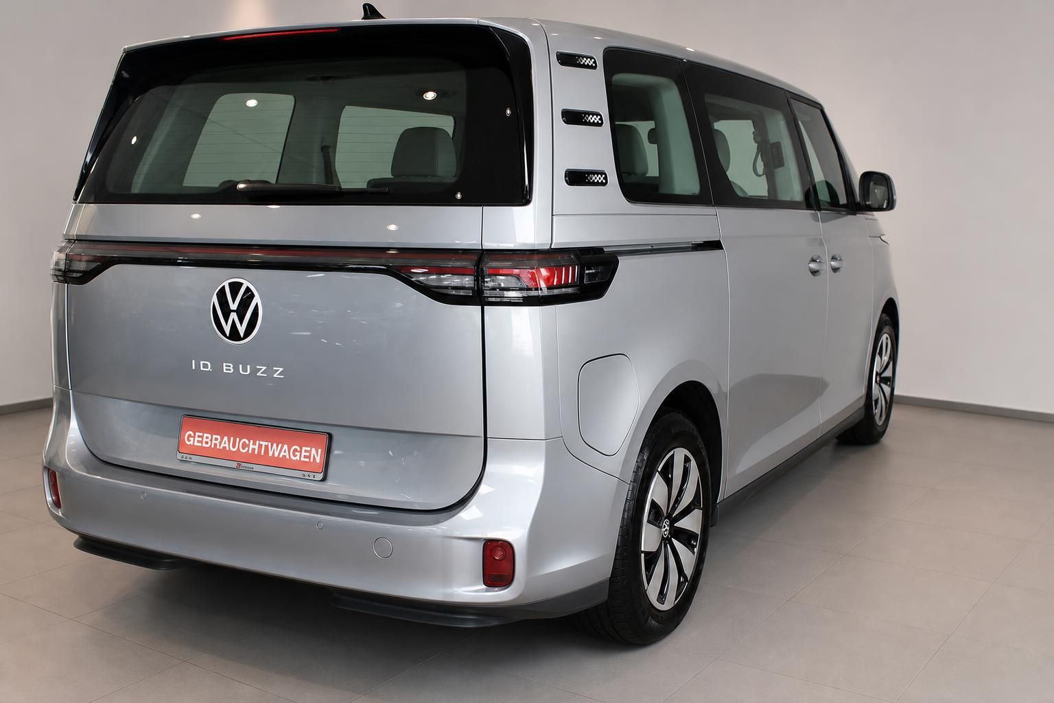 VW ID. Buzz Gebrauchtwagen in Silber, Heckansicht im Autohaus