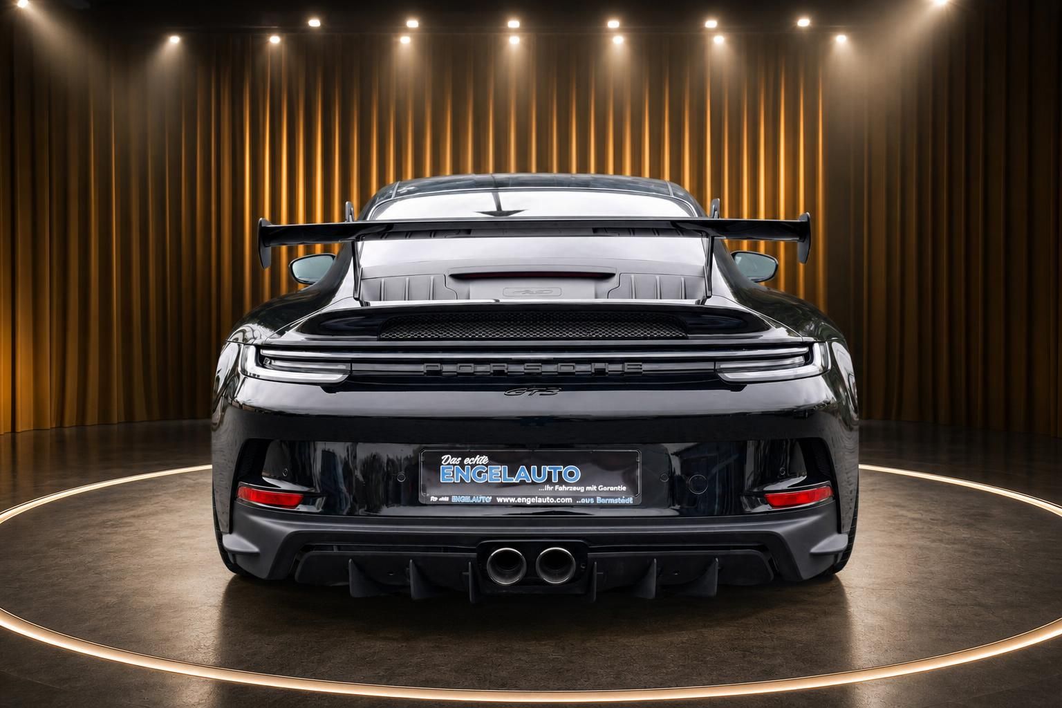 Porsche 911 GT3 schwarz Heckansicht mit großem Heckspoiler und Porsche-Schriftzug auf Drehbühne