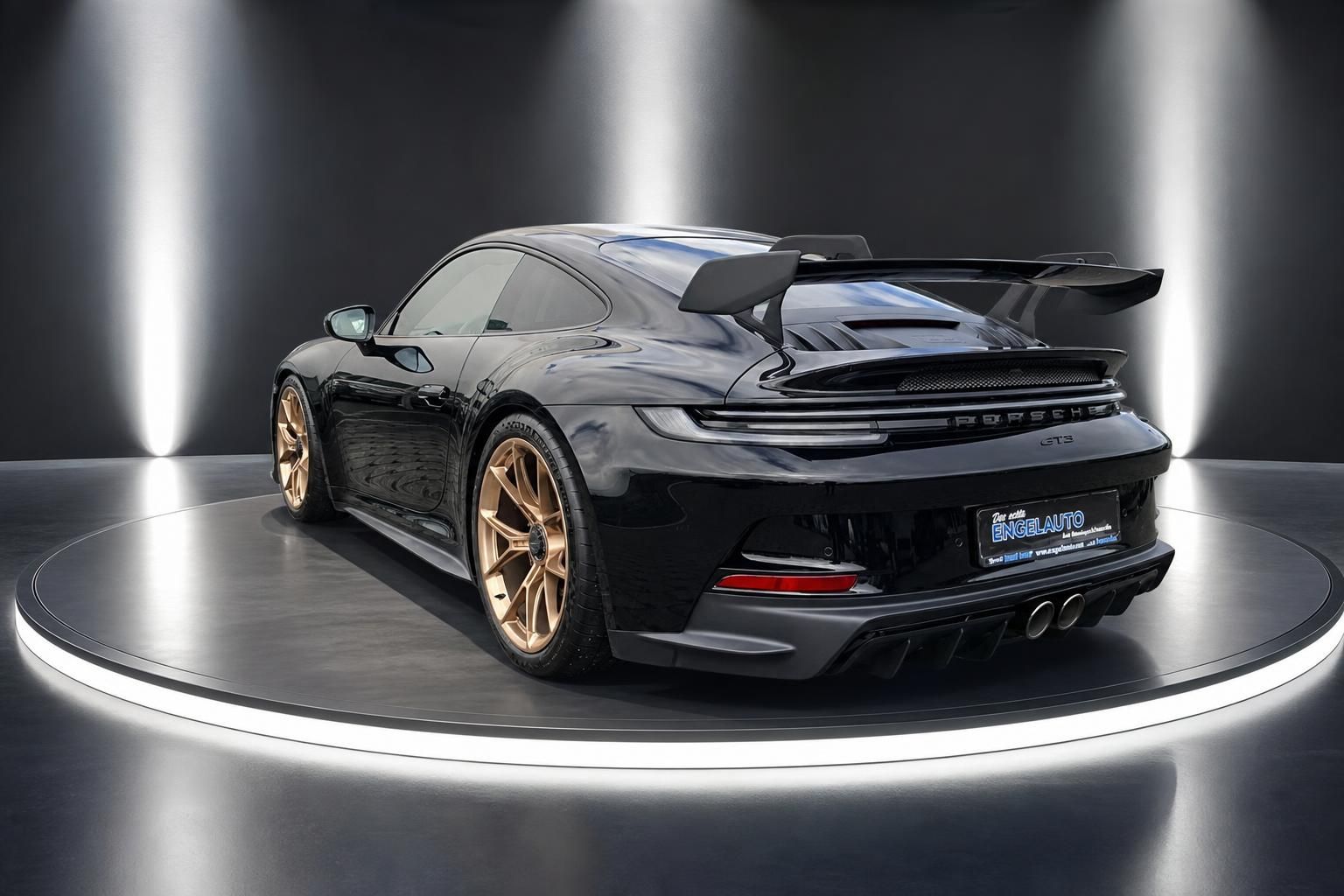 Porsche 911 GT3 schwarz Heckansicht mit großem Spoiler und goldenen Felgen auf Drehbühne