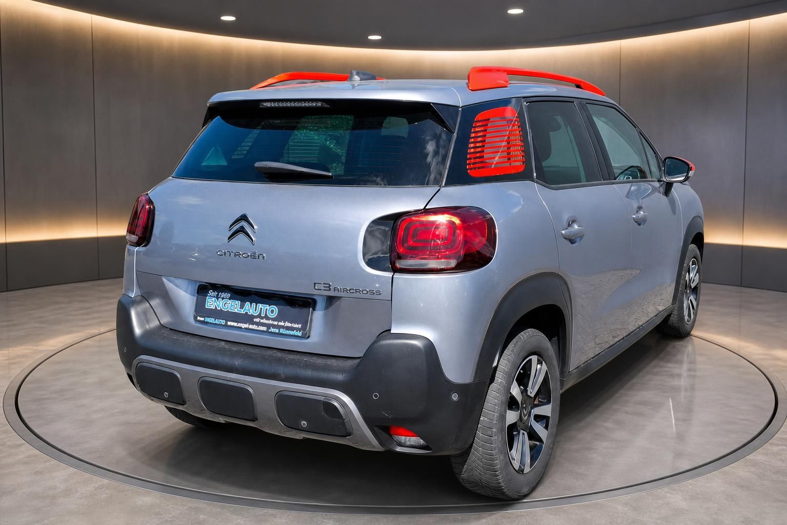 Citroën C3 Aircross in Grau, Heckansicht mit rotem Dach im Showroom