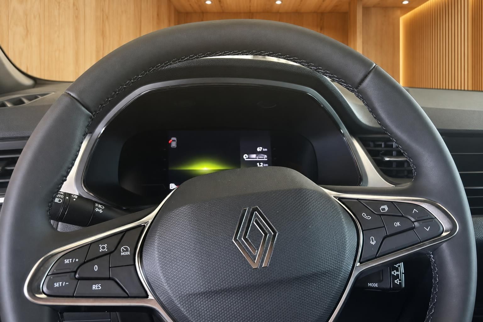 Renault Lenkrad Nahaufnahme mit Multifunktionstasten und digitalem Tacho im Hintergrund