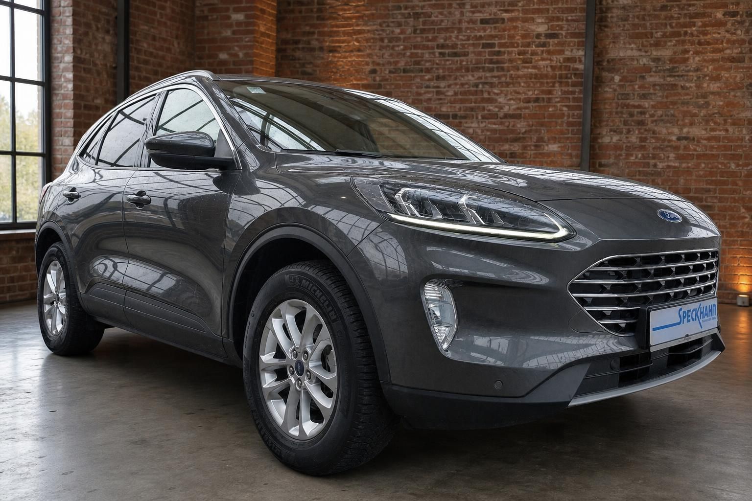 Ford Kuga grau metallic Frontansicht in Industriehalle mit Backsteinwand