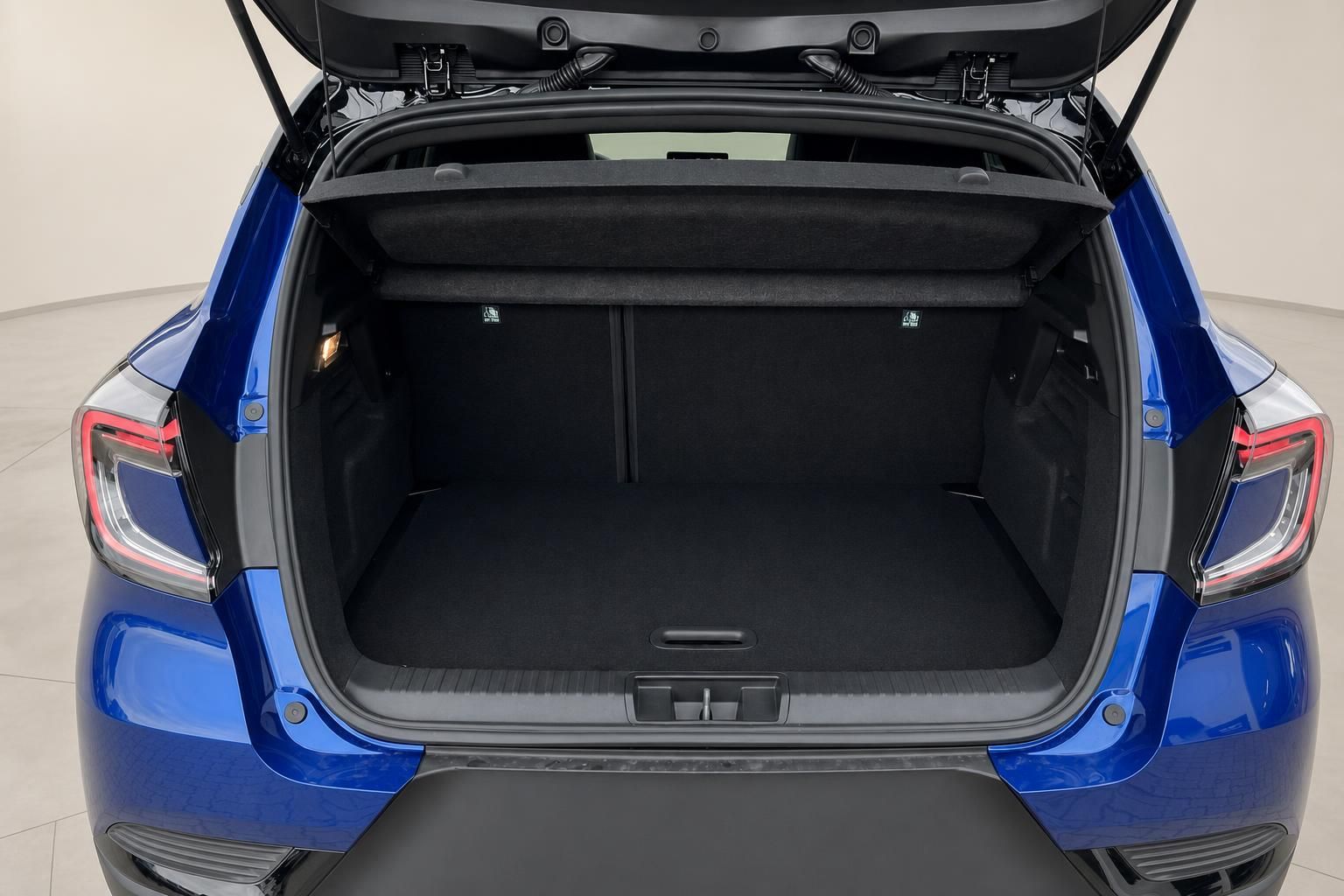 Geöffneter Kofferraum eines blauen Fahrzeugs mit schwarzer Innenverkleidung und LED-Rückleuchten