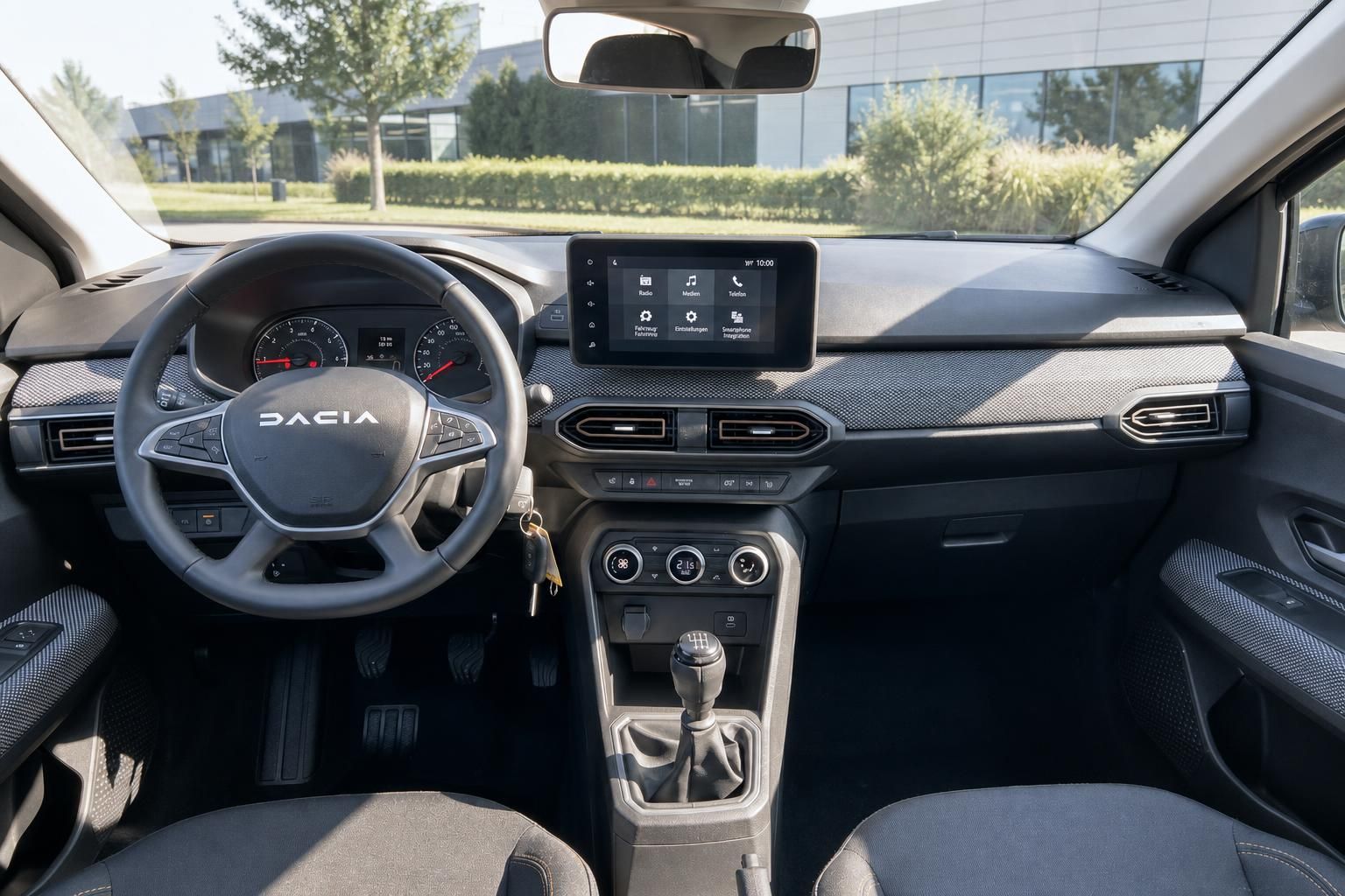 Dacia Innenraum Armaturenbrett - Fahrersicht mit Touchscreen, Klimaanlage und Schaltgetriebe
