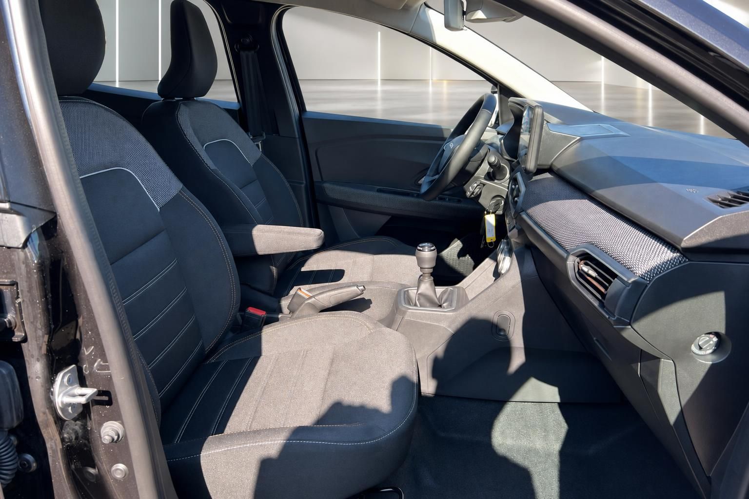 Dacia Fahrzeuginnenraum mit Vordersitzen, Schaltknauf und modernem Dashboard