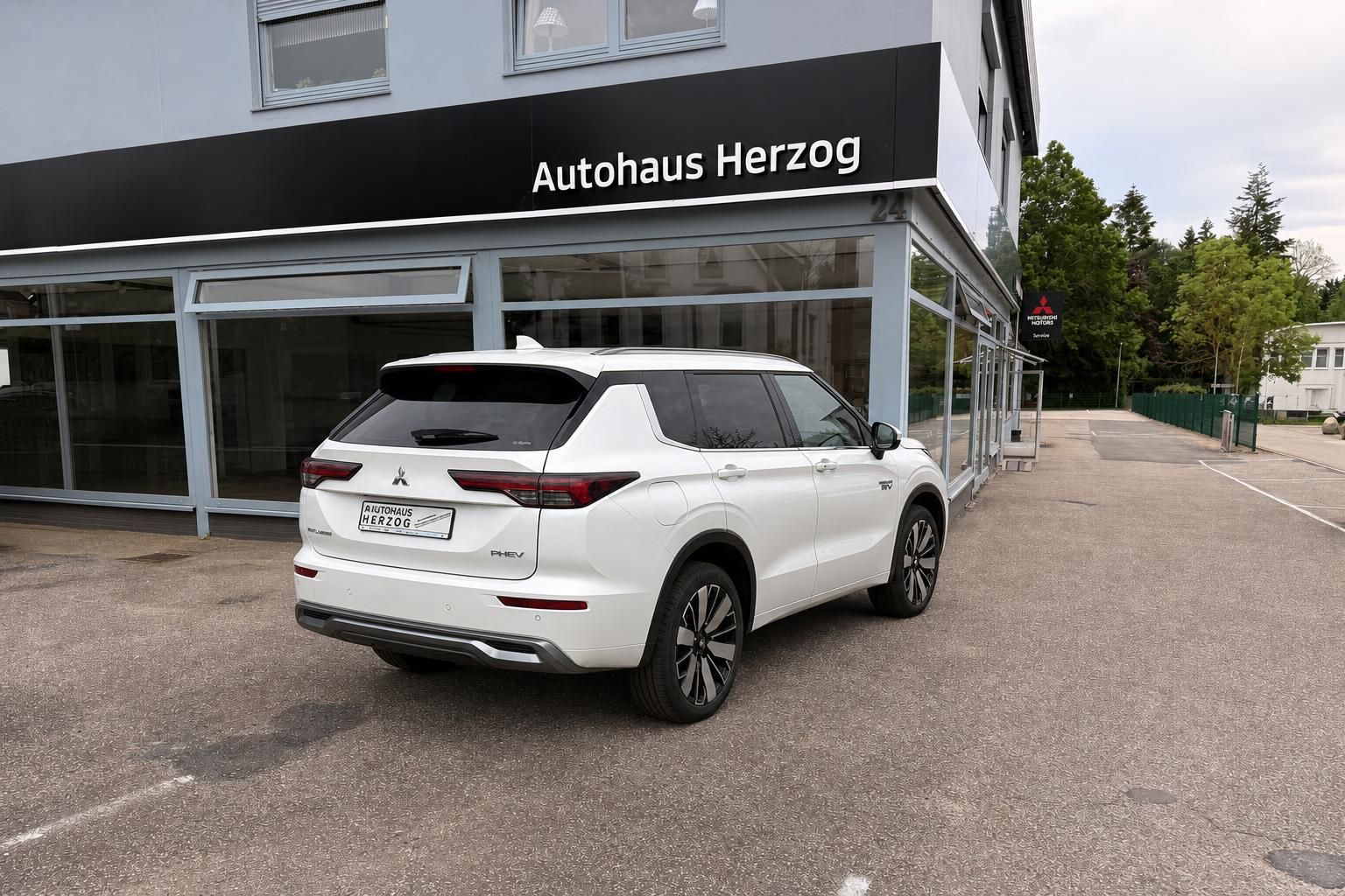 Weißer Mitsubishi Outlander PHEV Heckansicht mit Autohaus Herzog Kennzeichen