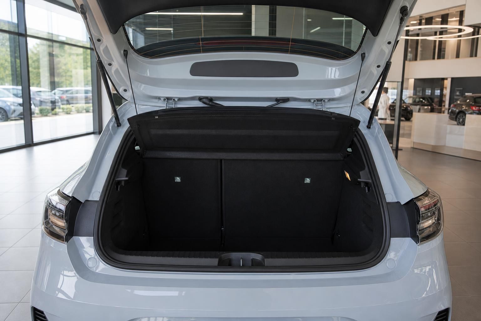Kofferraum eines weißen Autos mit geöffneter Heckklappe und schwarzer Innenausstattung im Autohaus