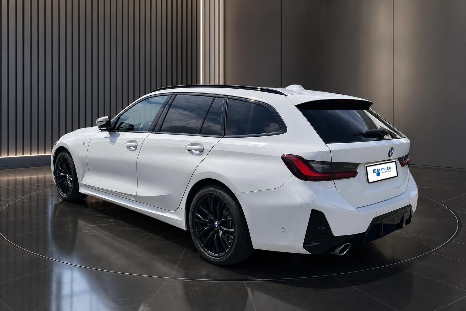 BMW 3er Touring weiß, Heckansicht seitlich im Autohaus Showroom