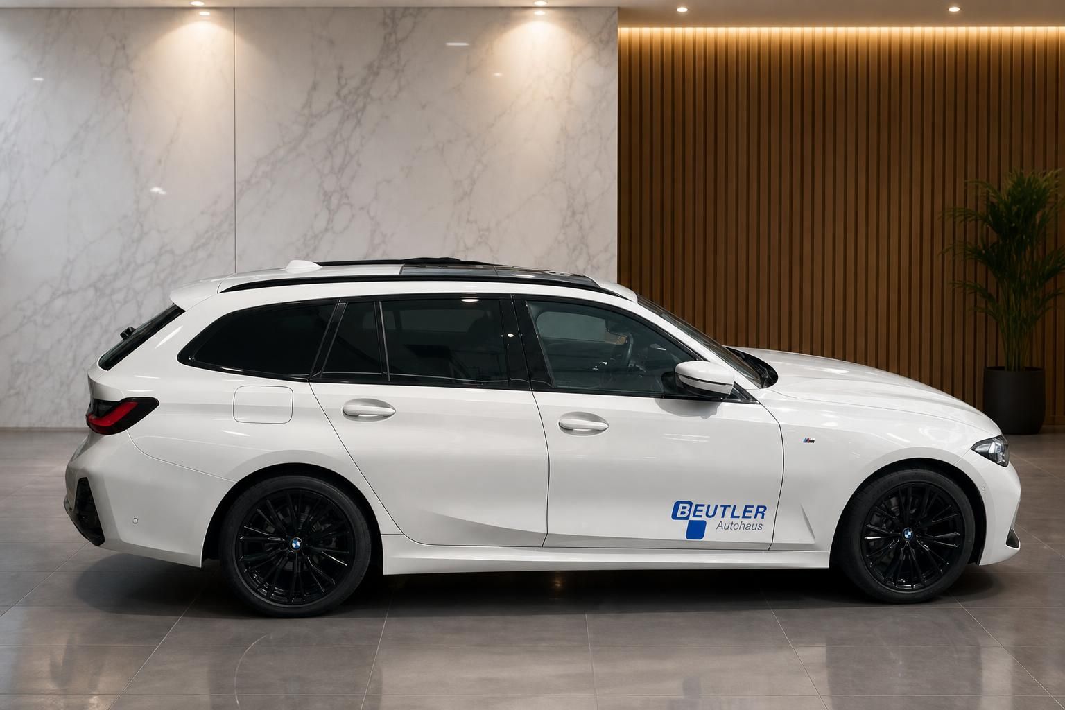 BMW 3er Touring weiss Seitenansicht mit schwarzen Alufelgen und Beutler-Beschriftung