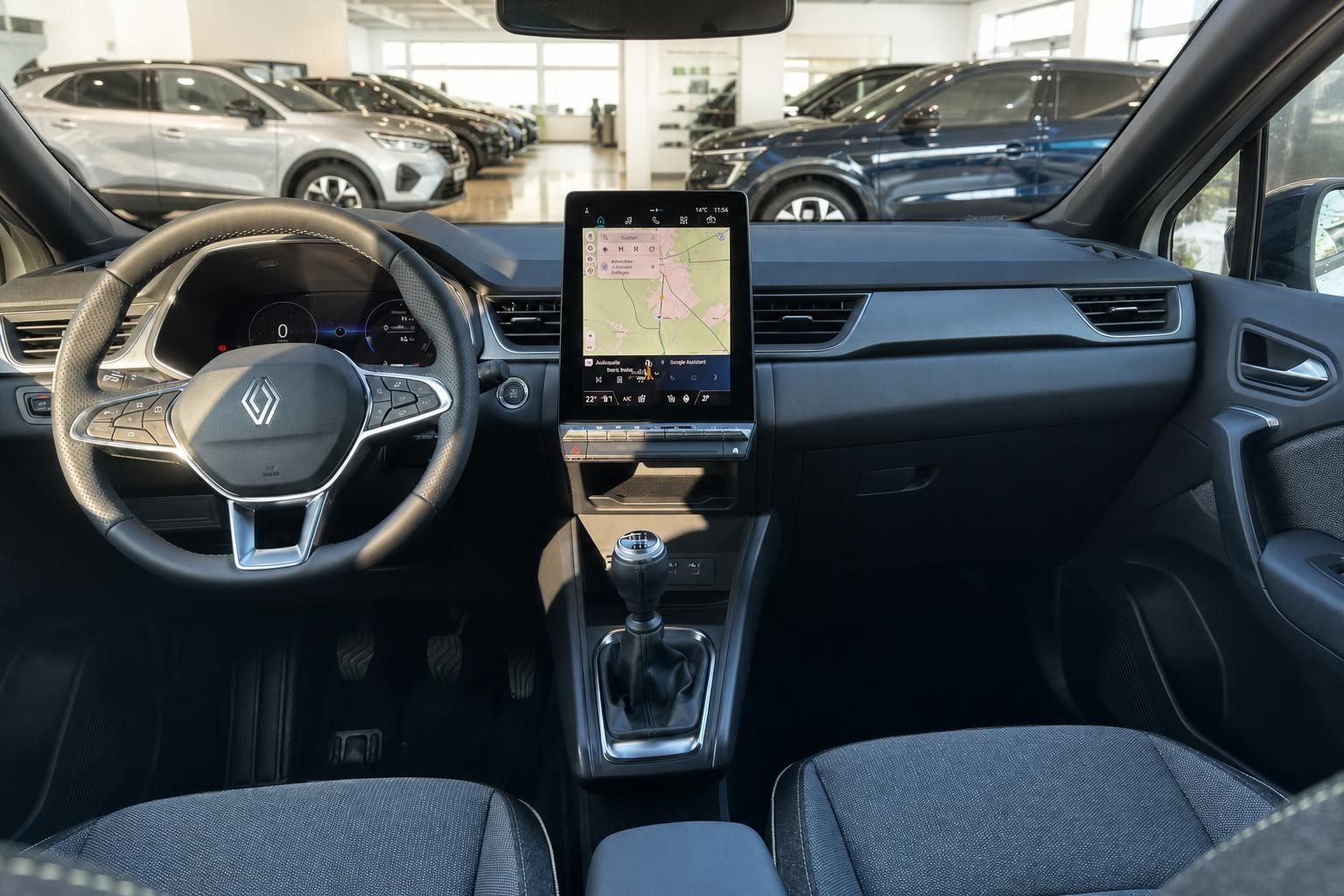 Renault Captur Innenraum mit Lenkrad, Touchscreen-Display und schwarzen Sitzen