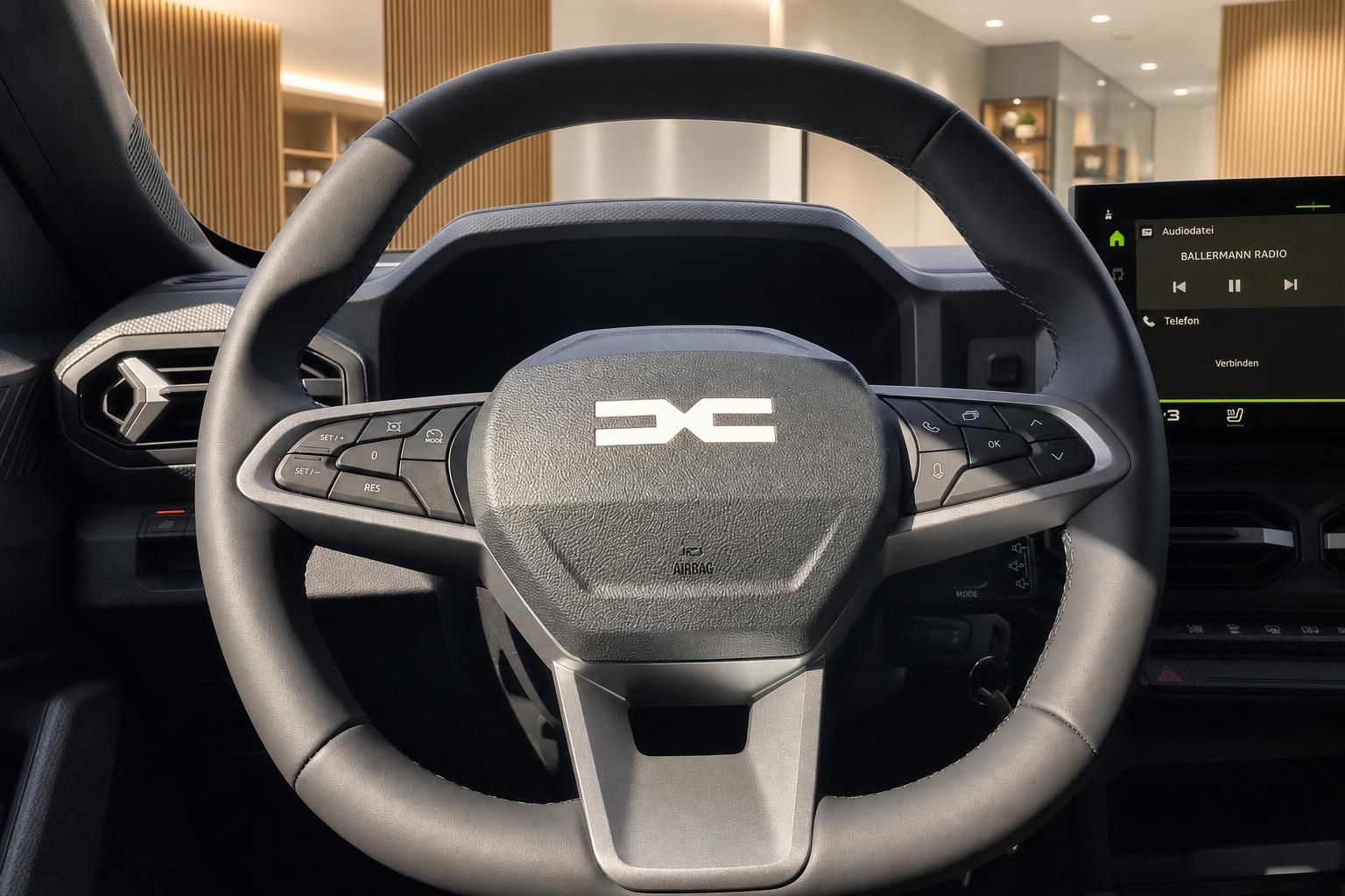 Dacia Innenraum Lenkrad Nahaufnahme mit Dacia-Logo und Infotainment-Display im Hintergrund