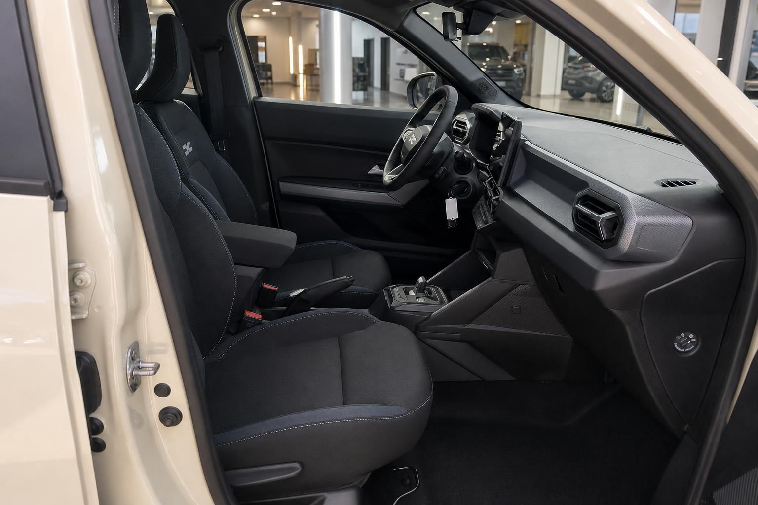 Dacia Fahrzeug Innenraum Fahrersitz und Beifahrersitz mit schwarzem Stoffbezug und Mittelkonsole