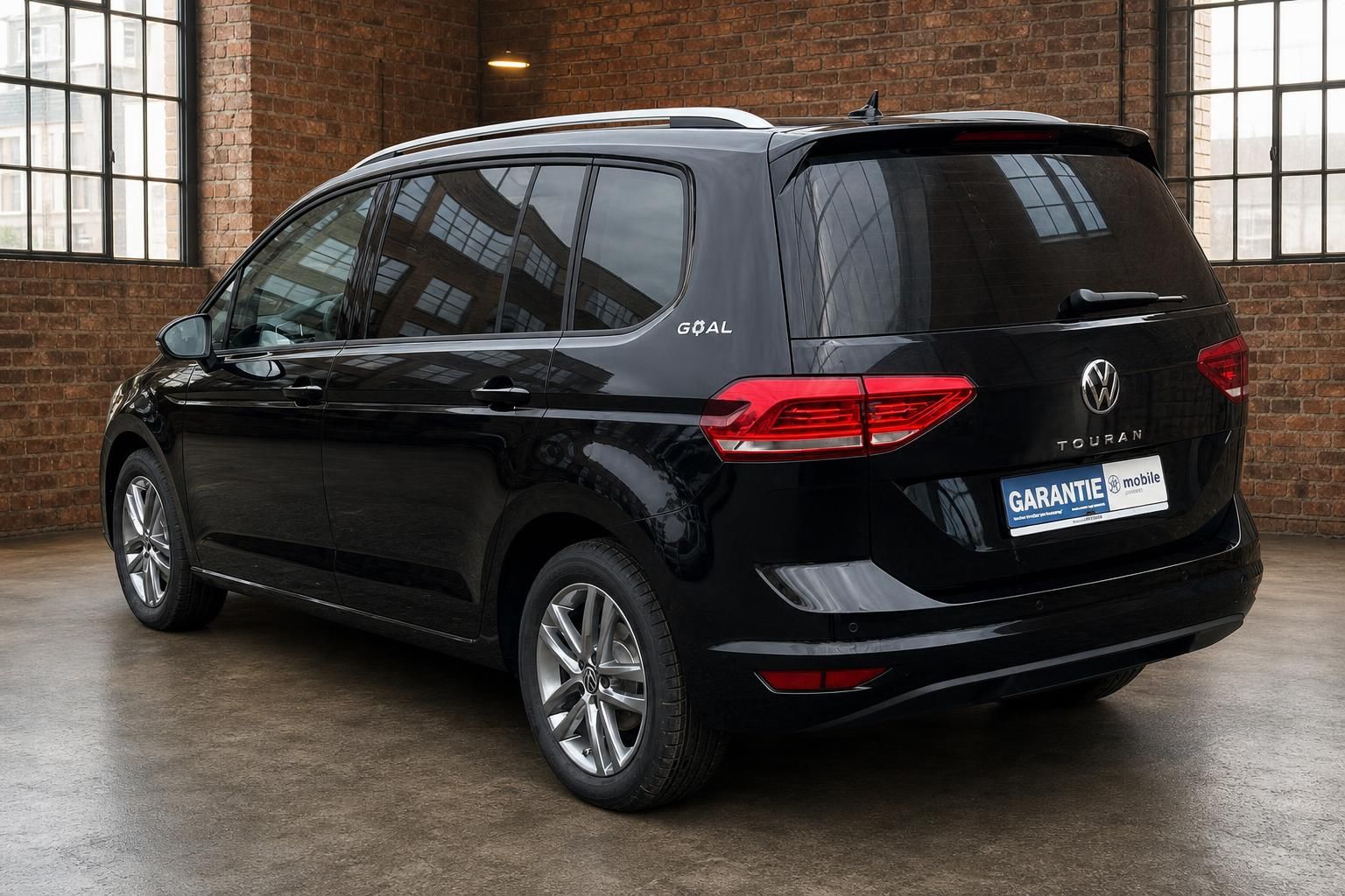 VW Touran schwarz Heckansicht seitlich in Industriehalle
