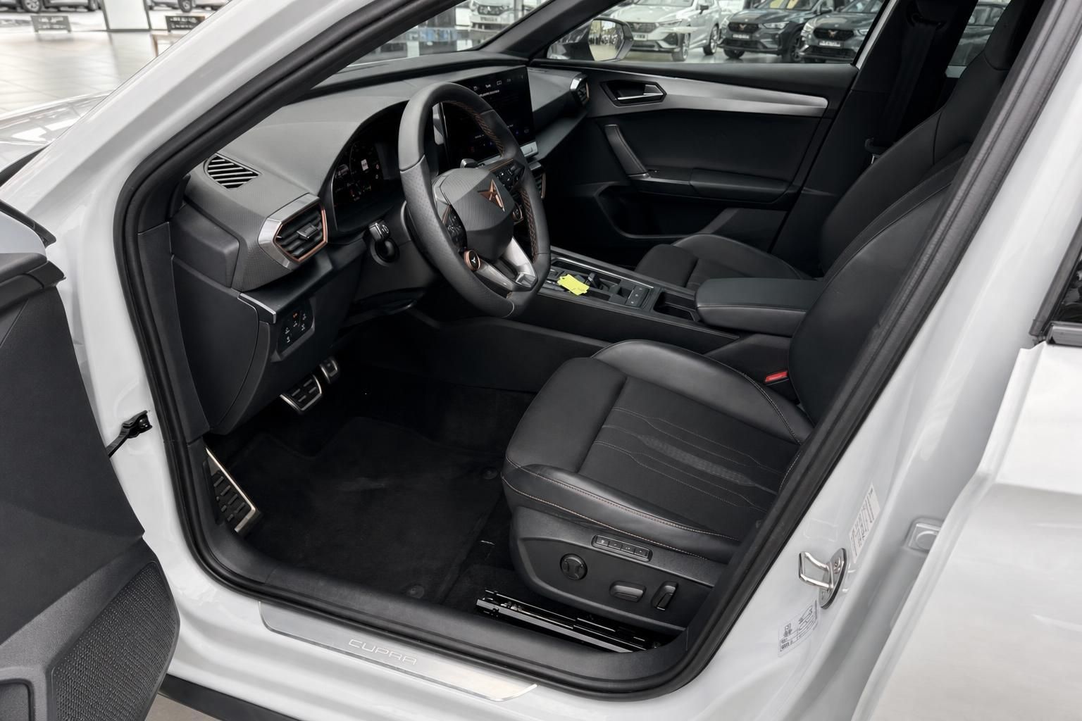 Cupra Fahrerraum mit Cockpit, Lenkrad und Ledersitzen durch offene Tür