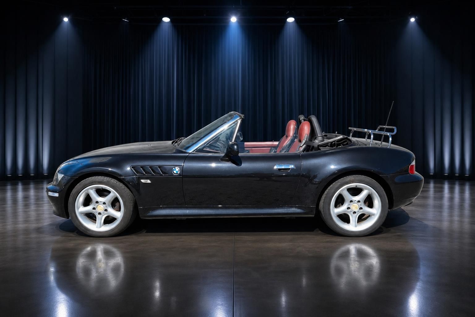 BMW Z3 Roadster schwarz Seitenansicht Cabrio mit roter Lederausstattung in Ausstellungsraum