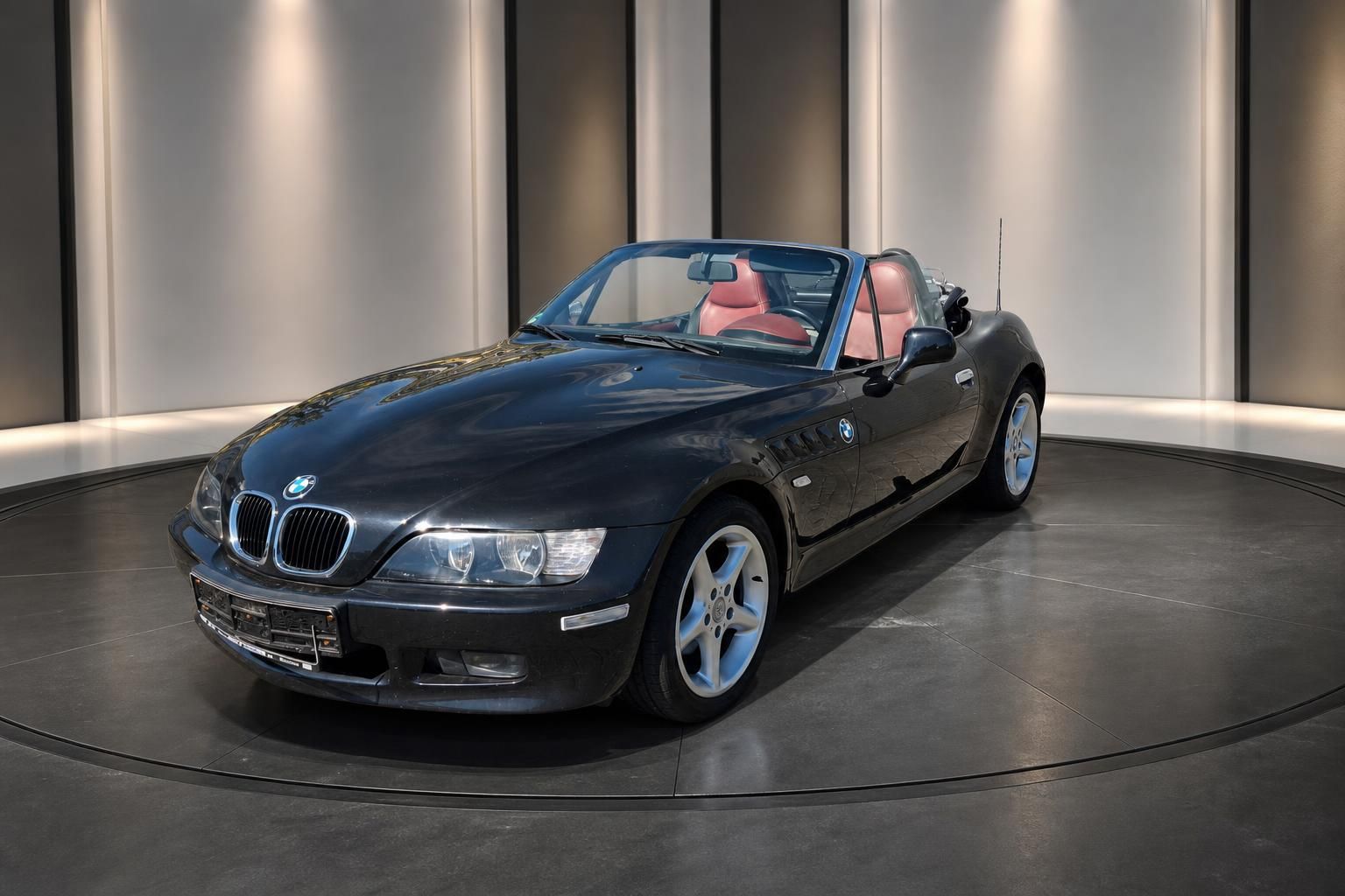 BMW Z3 Cabrio schwarz Dreiviertel-Seitenansicht mit offenen Verdeck und roten Sitzen