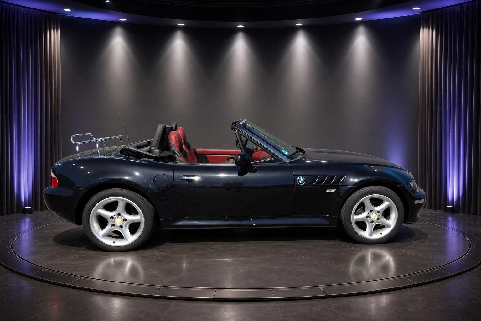 BMW Z3 Cabrio dunkelblau Seitenansicht mit roter Lederausstattung und offenem Verdeck