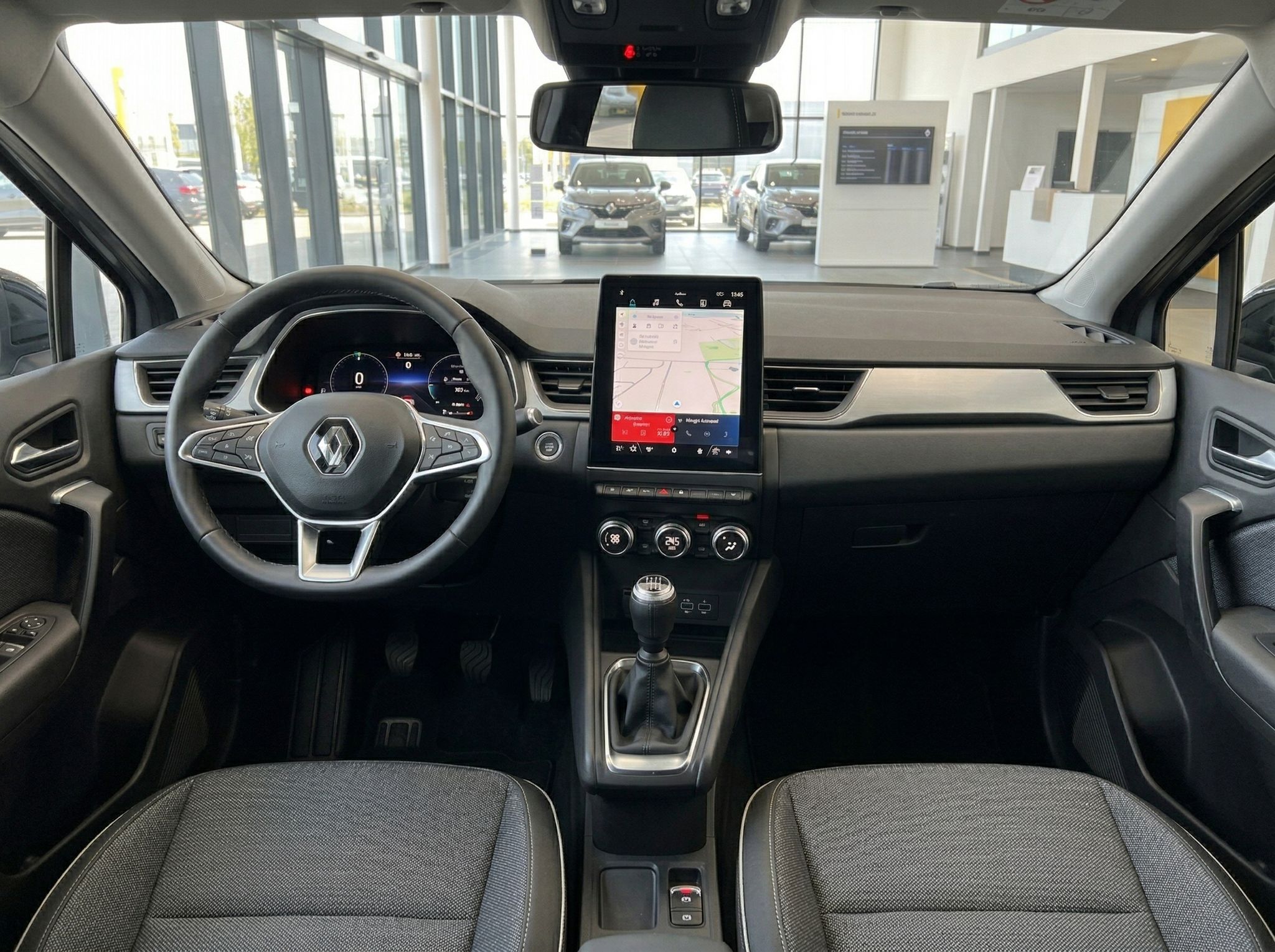 Renault Fahrzeug Innenraum mit Lenkrad, Touchscreen-Display und Schaltgetriebe in grauem Design